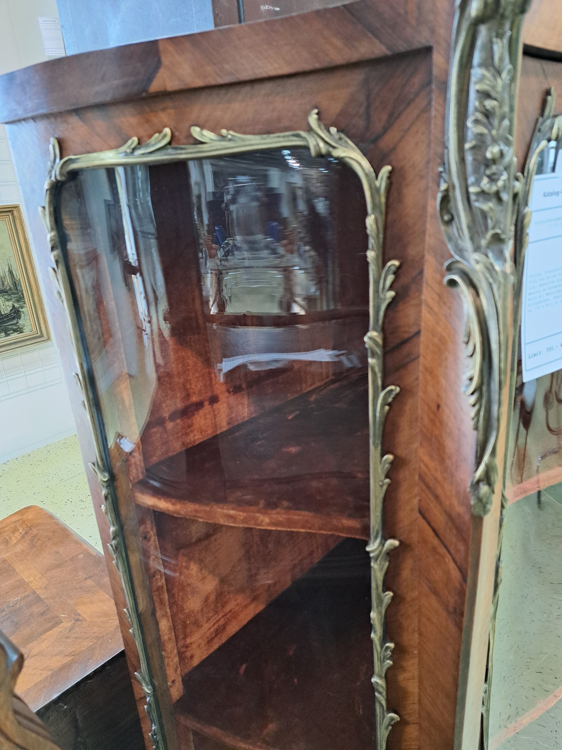 Detail a: Vitrine, Frankreich, um 1860, Nußbaum, Front und Seiten stark geschwungen mit orig. gewalztem Glas, eingefaßt mit Messing im Ränderdekor, Kanten ...
