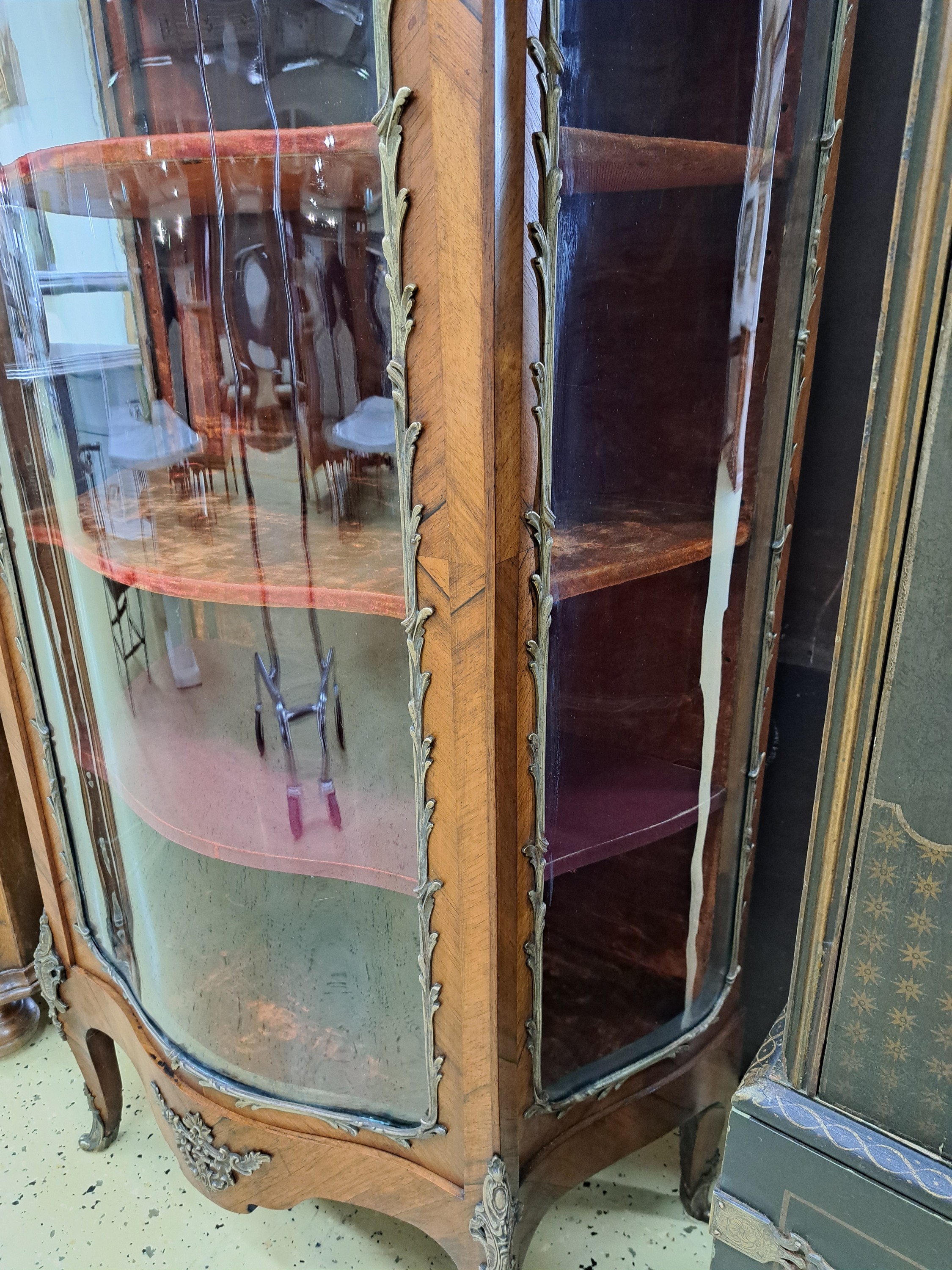 Detail d: Vitrine, Frankreich, um 1860, Nußbaum, Front und Seiten stark geschwungen mit orig. gewalztem Glas, eingefaßt mit Messing im Ränderdekor, Kanten ...