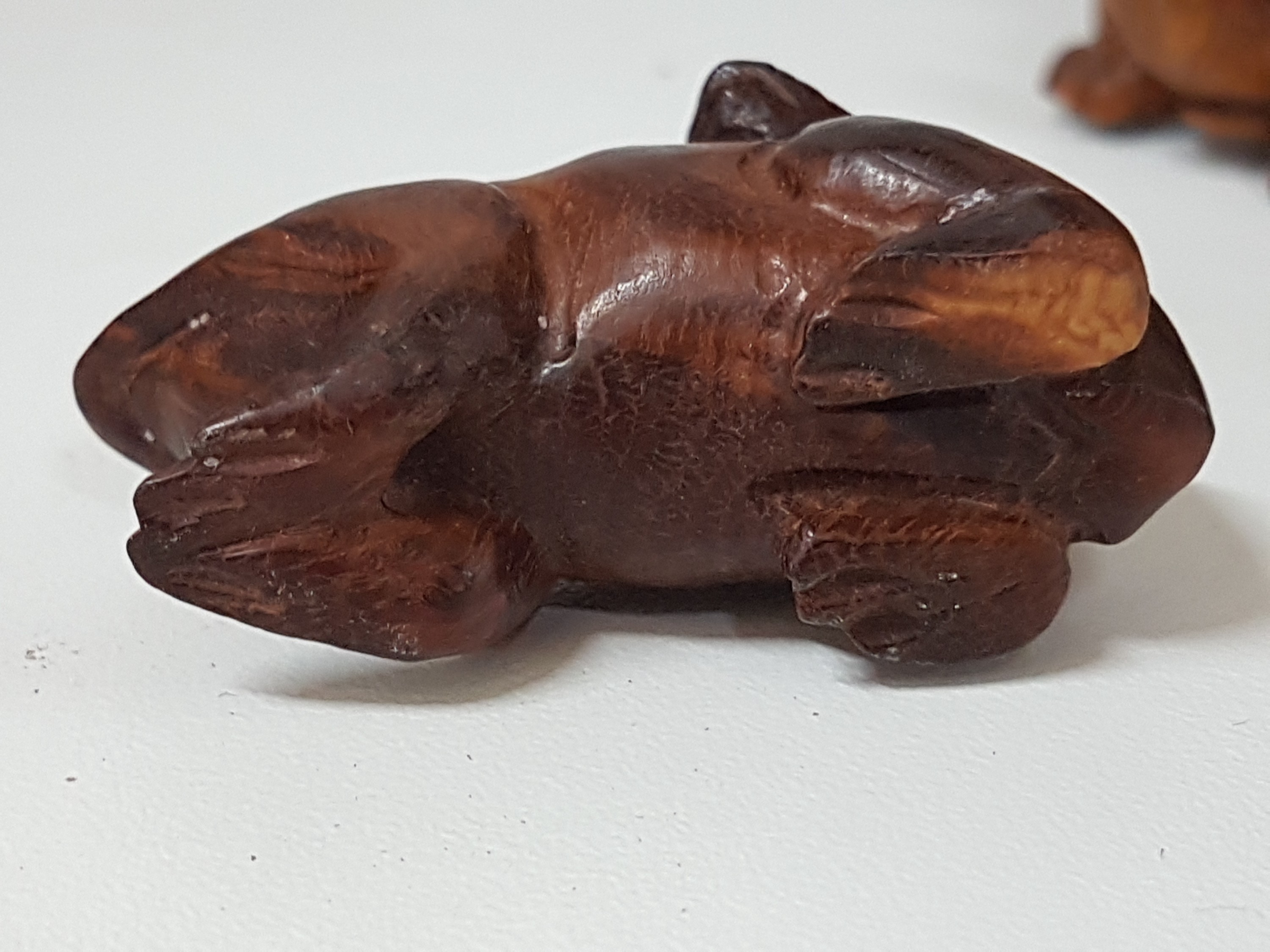 Detail d: 3 Netsuke aus Holz, Japan, Meiji um 1900, Rosenholz, kleiner Affe mit Bambuskringel H. 2,5 cm, Ratte auf Schildkröte reitend H. 4cm, 2 Frösche H. ...