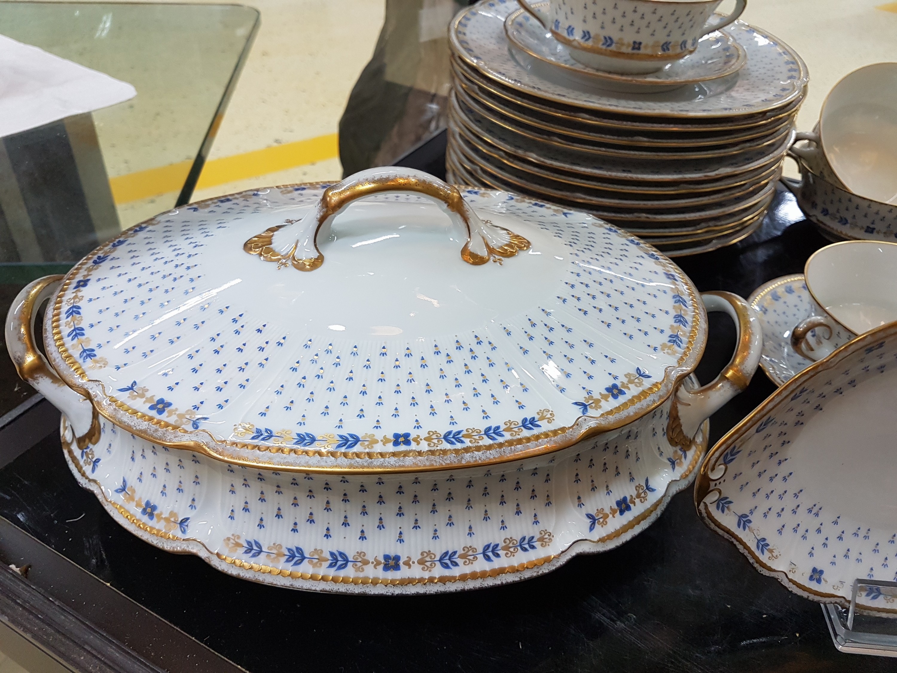 Detail c: Speiseservice, Limoges, Anjou, Porzellan, abstrakt floraler Dekor in Blau, goldgehöht: 12 Speiseteller D.ca. 24.5cm, 12 Suppentassen mit ...