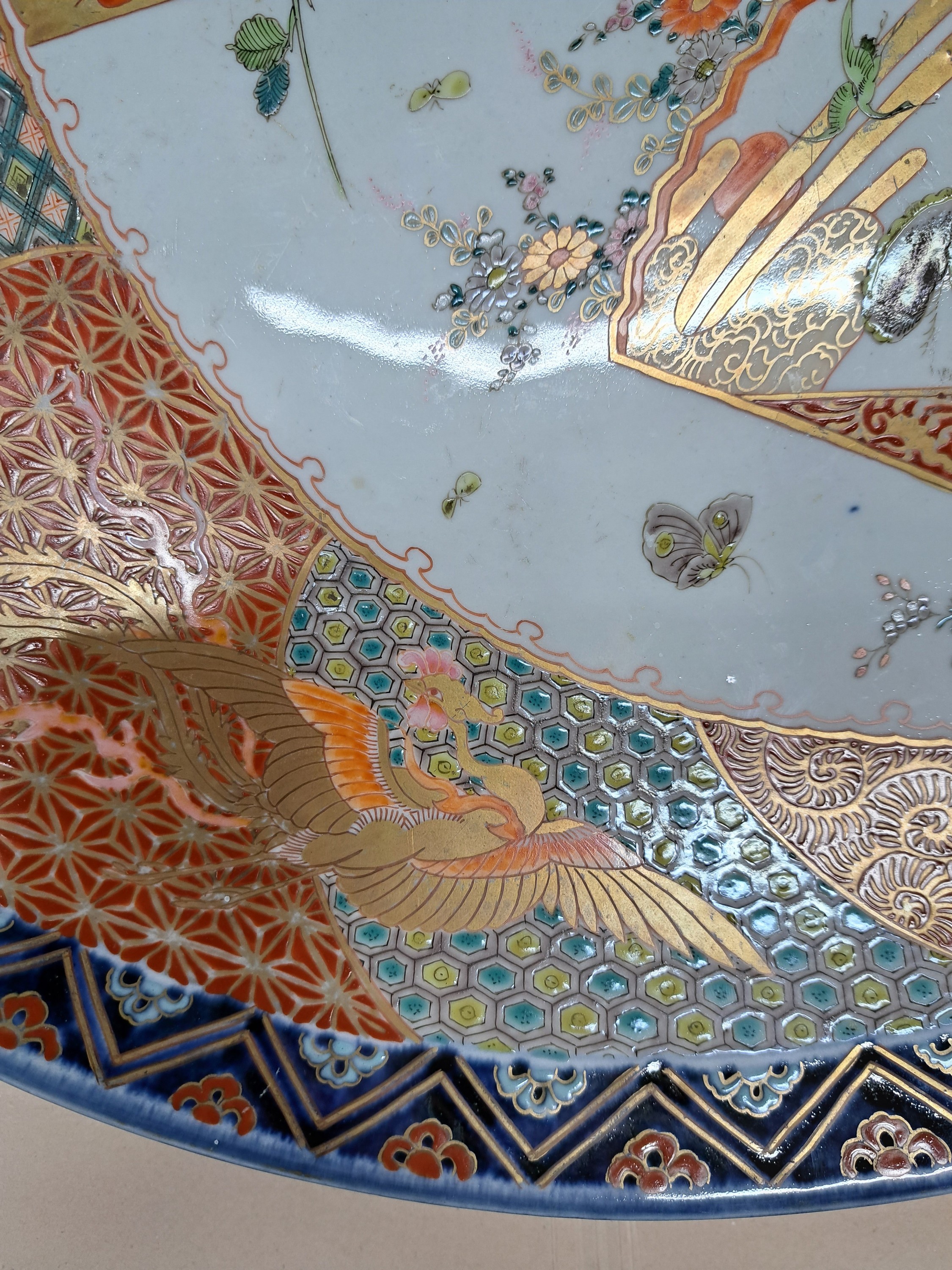 Detail j: Großer Imari Teller, Japan, um 1860-70, Porzellan, aufwändige Feldermalerei von Landschaften in verschiedenen Ebenen, Gartenlandschaften und Vögel ...