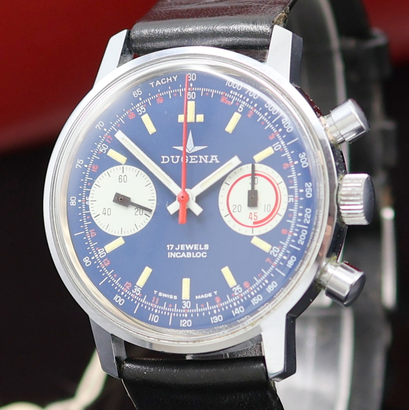 Detail a: DUGENA Herrenarmbanduhr mit Chronograph, Handaufzug, Schweiz um 1970, verchr. Geh. m. verschr. Stahlboden, blaues Zifferbl. m. Tritium-Leuchtindizes, ...