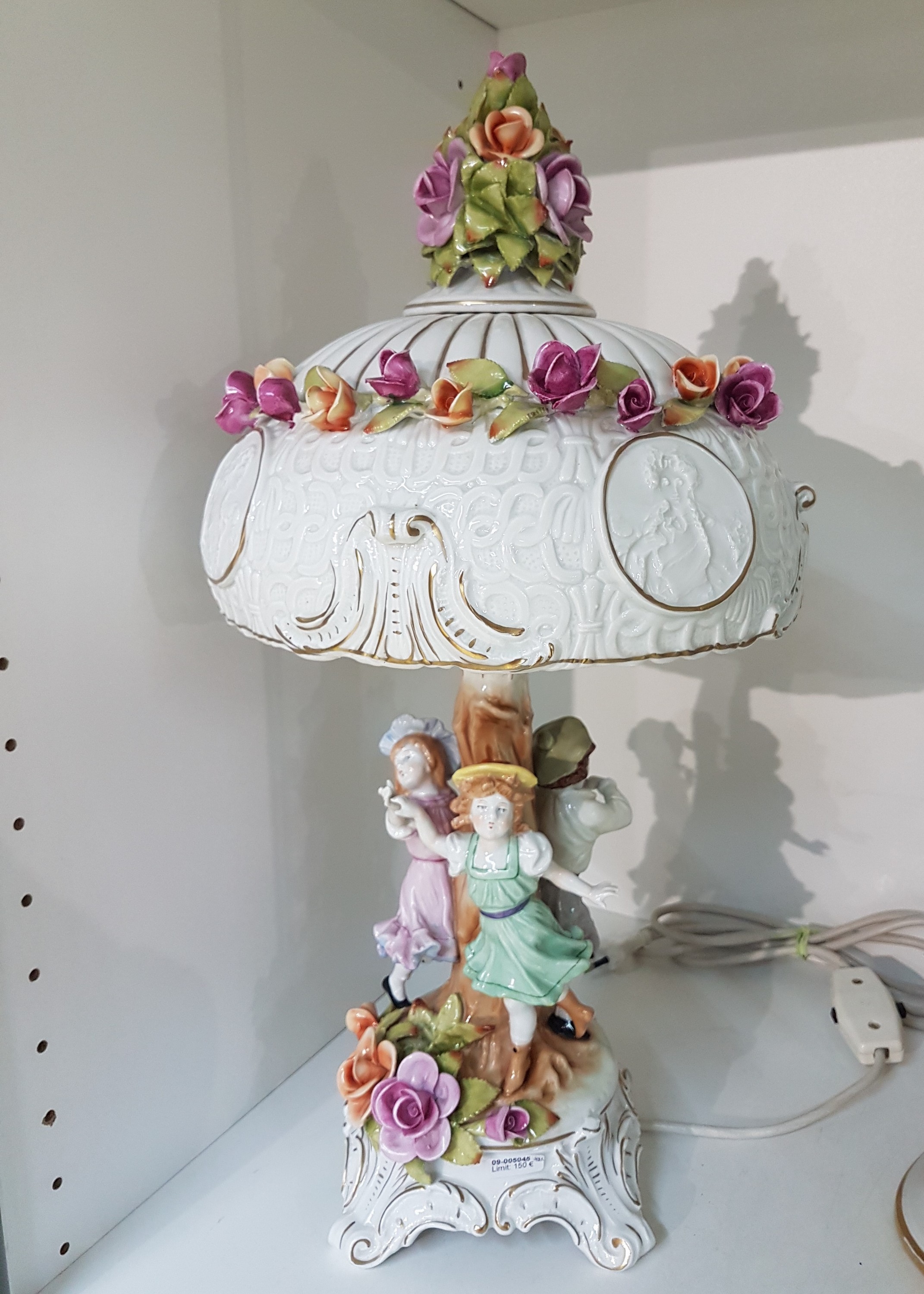 Detail a: Tischlampe, Plaue Thüringen, 20. Jh., Porzellan, reich appliziert mit drei Kinderfiguren und zahlreichen Blättern- und Blüten, Schirm mit ...