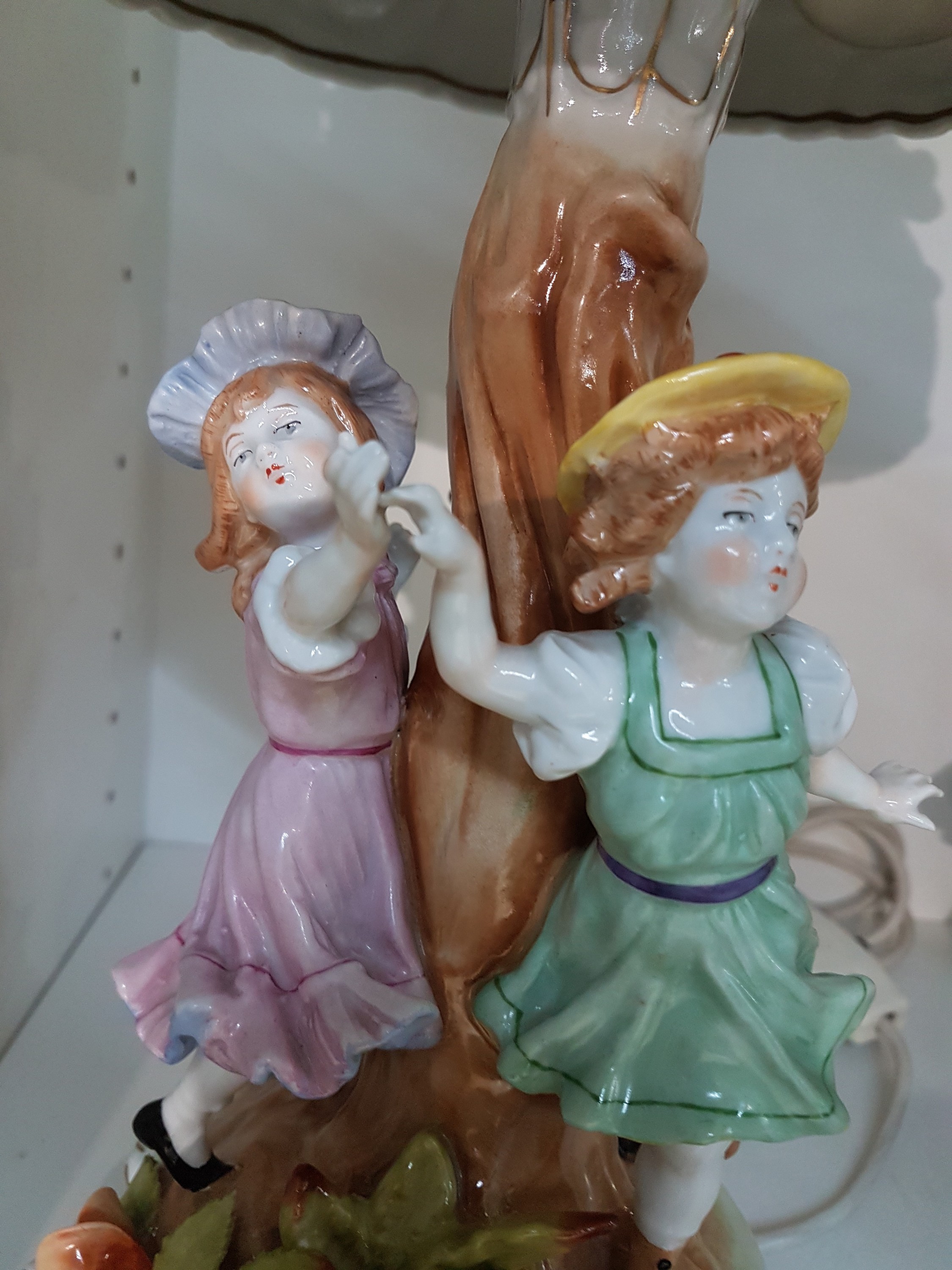 Detail c: Tischlampe, Plaue Thüringen, 20. Jh., Porzellan, reich appliziert mit drei Kinderfiguren und zahlreichen Blättern- und Blüten, Schirm mit ...