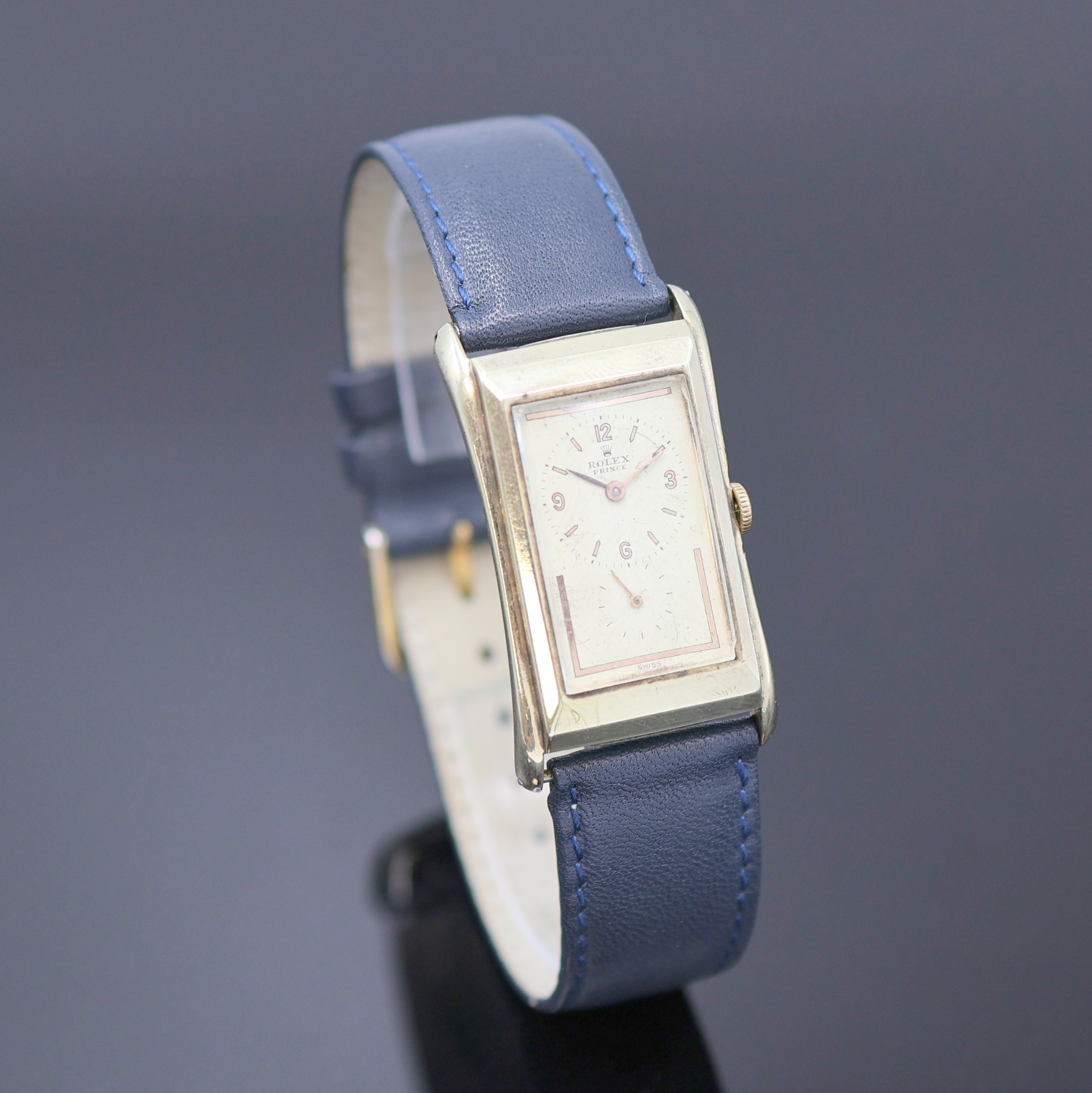 Detail b: ROLEX Prince Armbanduhr Referenz 1490, Schweiz um 1935, Handaufzug, rechteckiges, teilw. verg. Stahlgeh., Boden aufgedr., silb. Zifferbl. ...