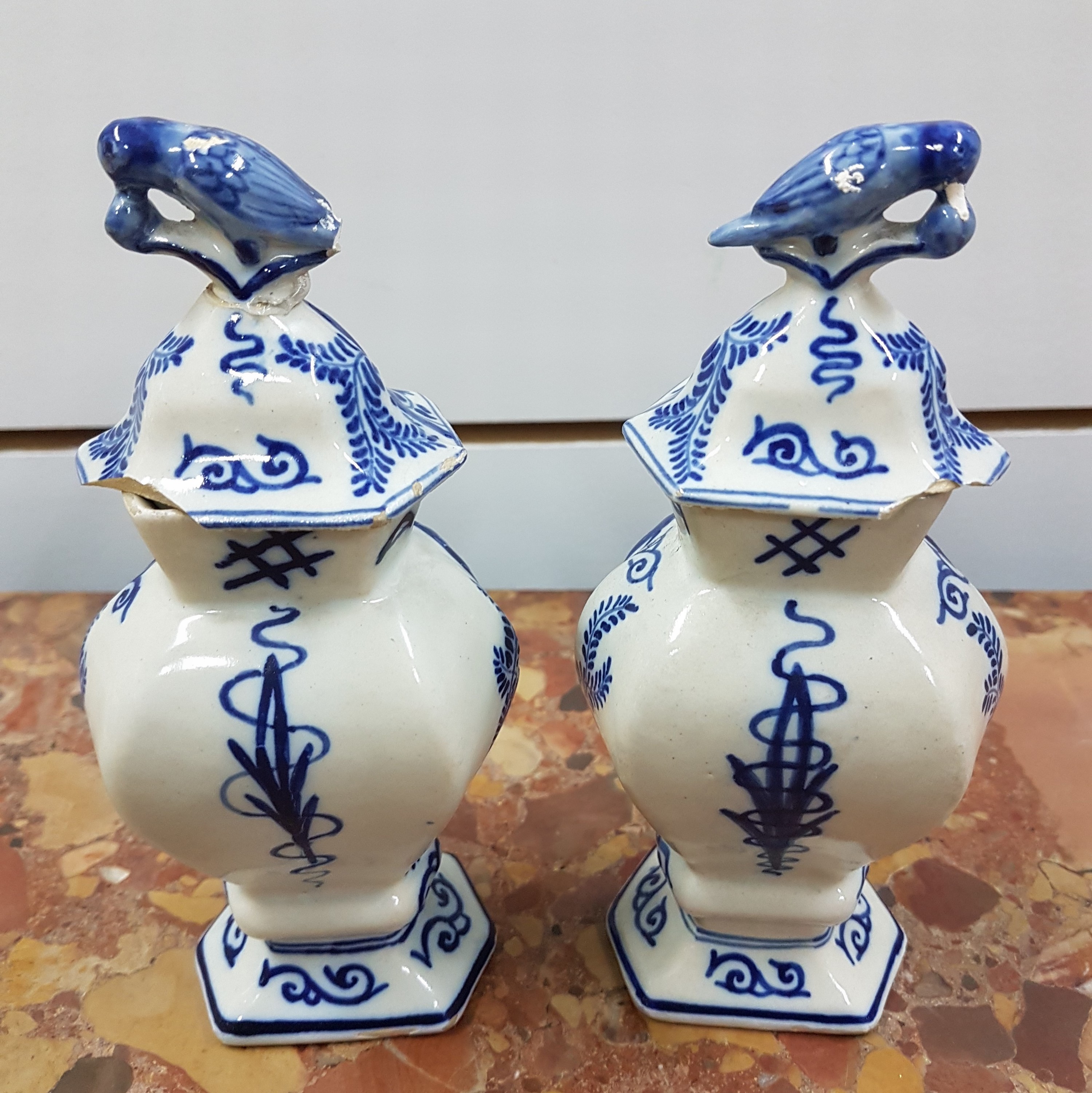 Detail c: Paar kleine Deckelvasen, Delft, sign. Duijn, 18. Jh., Fayence, Blaumalerei, Bekrönungen in Vogelform bestoßen, ein Deckel besch., H. ca. 17cm