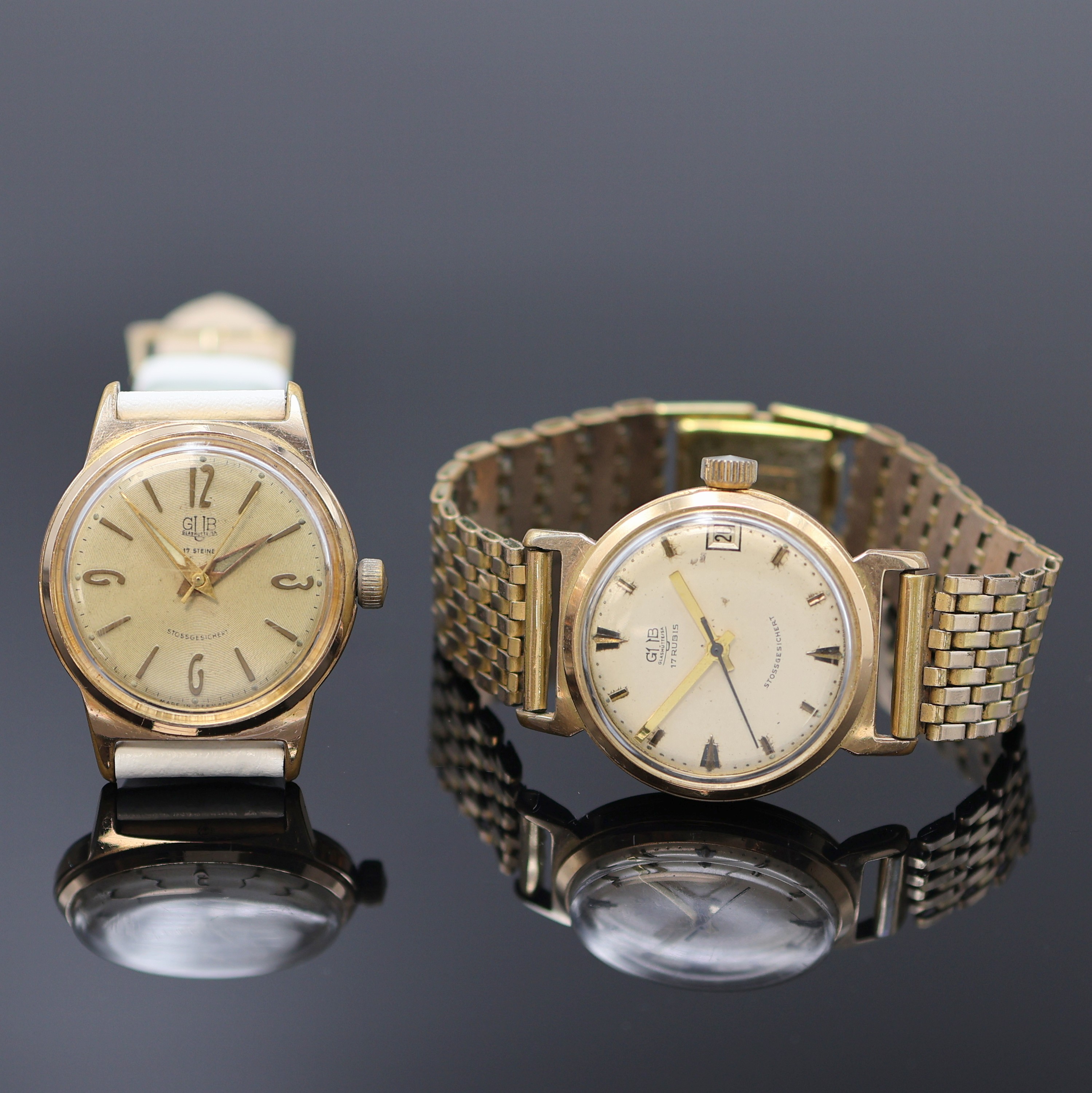 GUB 2 vergoldete Herrenarmbanduhren Kaliber 69.1/70.1, DDR um 1968, Handaufzug, 2-tlg. Geh. m. aufgedr. Stahlböden, silb. Zifferblätter pat./fl., ...