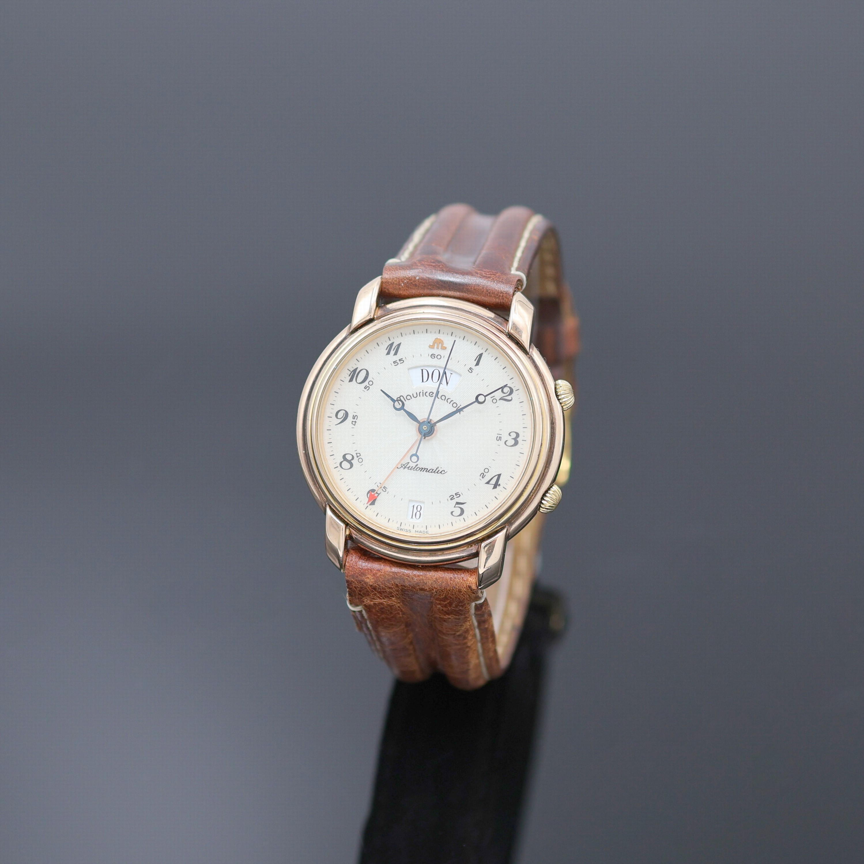 MAURICE LACROIX Armbandwecker im vergoldeten Gehäuse, Schweiz um 1990, Automatik, beids. vergl., rotverg. Geh., Boden aufgedr., translucid lack. ...