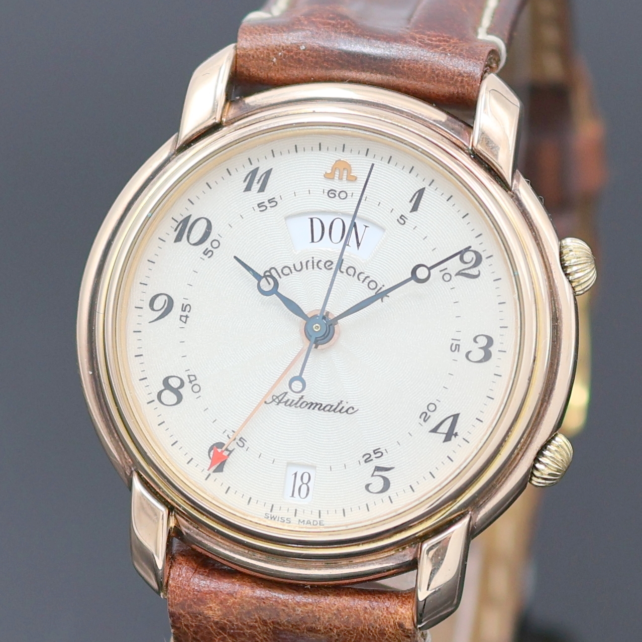 Detail a: MAURICE LACROIX Armbandwecker im vergoldeten Gehäuse, Schweiz um 1990, Automatik, beids. vergl., rotverg. Geh., Boden aufgedr., translucid lack. ...