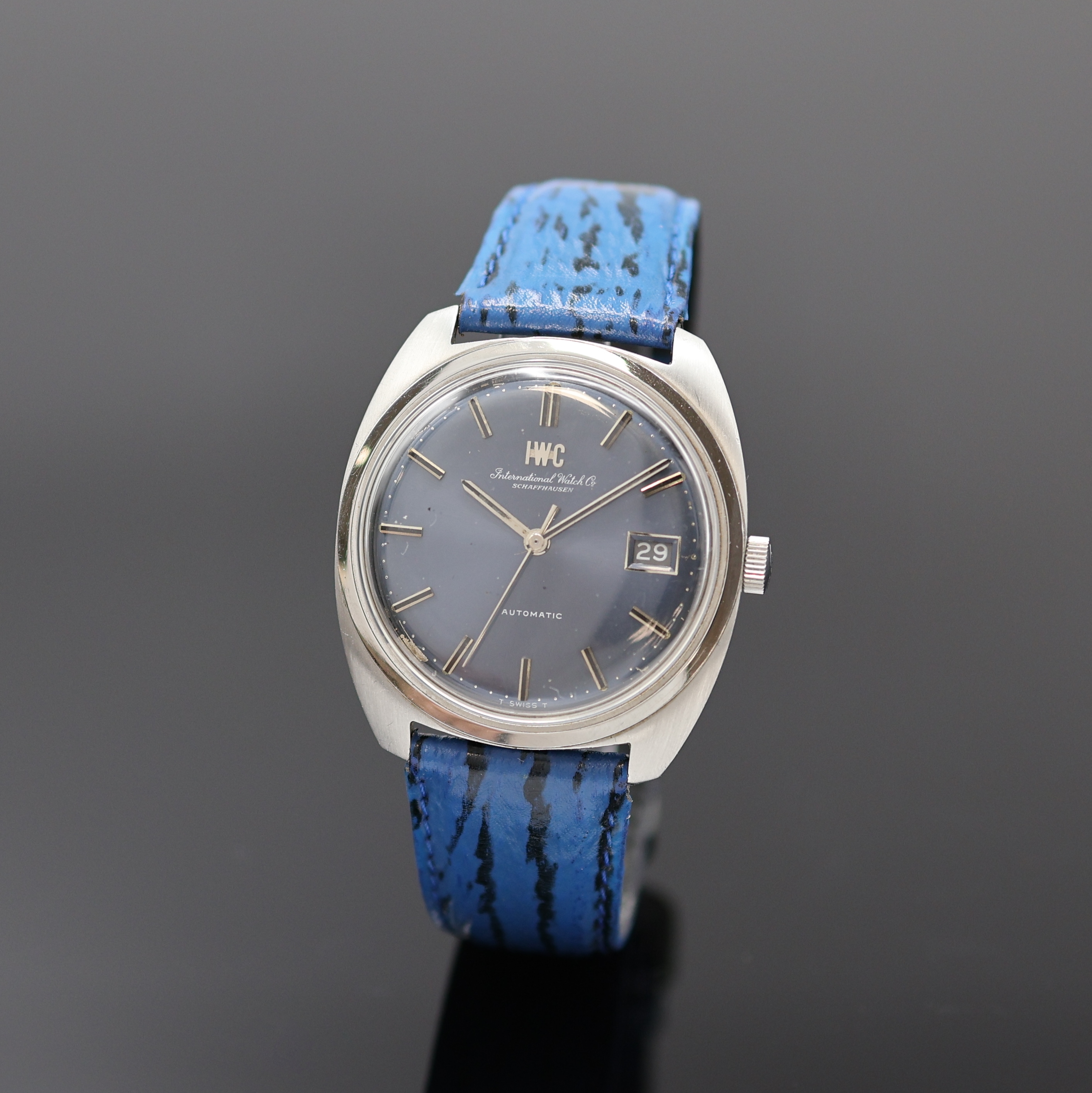 IWC Kaliber 8541B Herrenarmbanduhr in Stahl, Schweiz um 1970, Automatik, tonneauförm. Geh., aufgedr. Glasboden später, orig. Krone, blaues ...