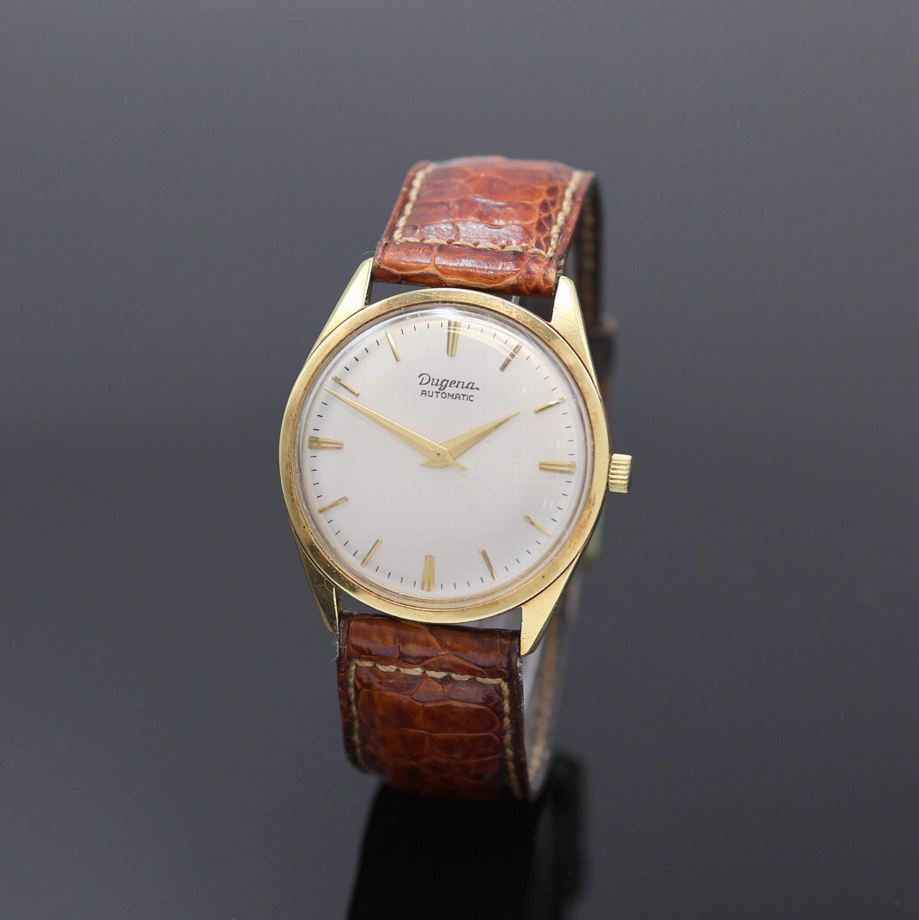 DUGENA Armbanduhr in GG 585/000, Schweiz um 1960, Automatik, 3-tlg. Geh., verschr. Glasboden später, silb. Zifferbl. rest., gold. Indizes u. Zeiger, ...
