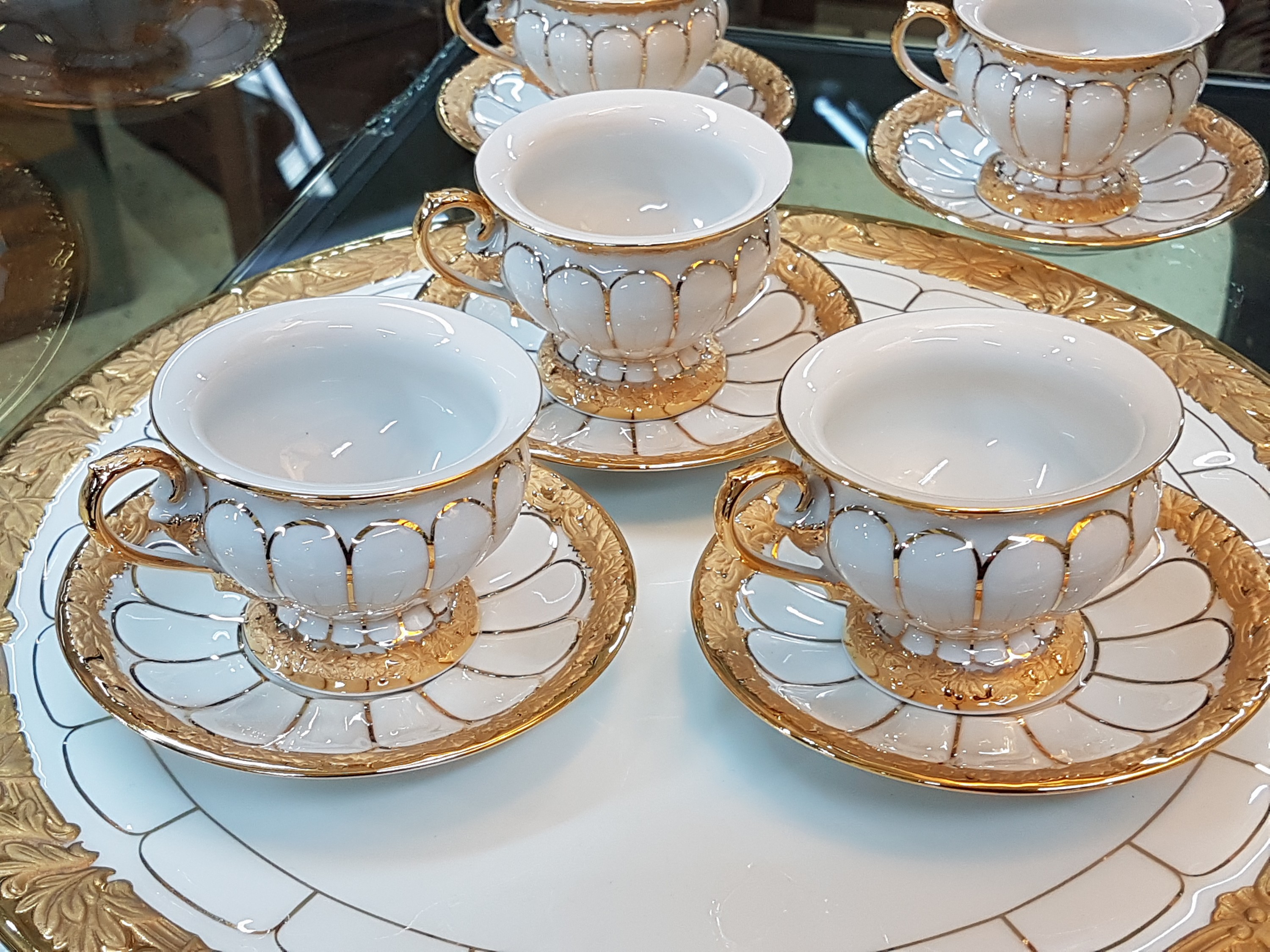 Detail b: 6 Mokkatassen und eine Kuchenplatte, Meissen, 20. Jh., 1. Wahl, X-Form, Relief matt- und glanzvergoldet, 6 Mokkatassen mit Untertassen, runde ...