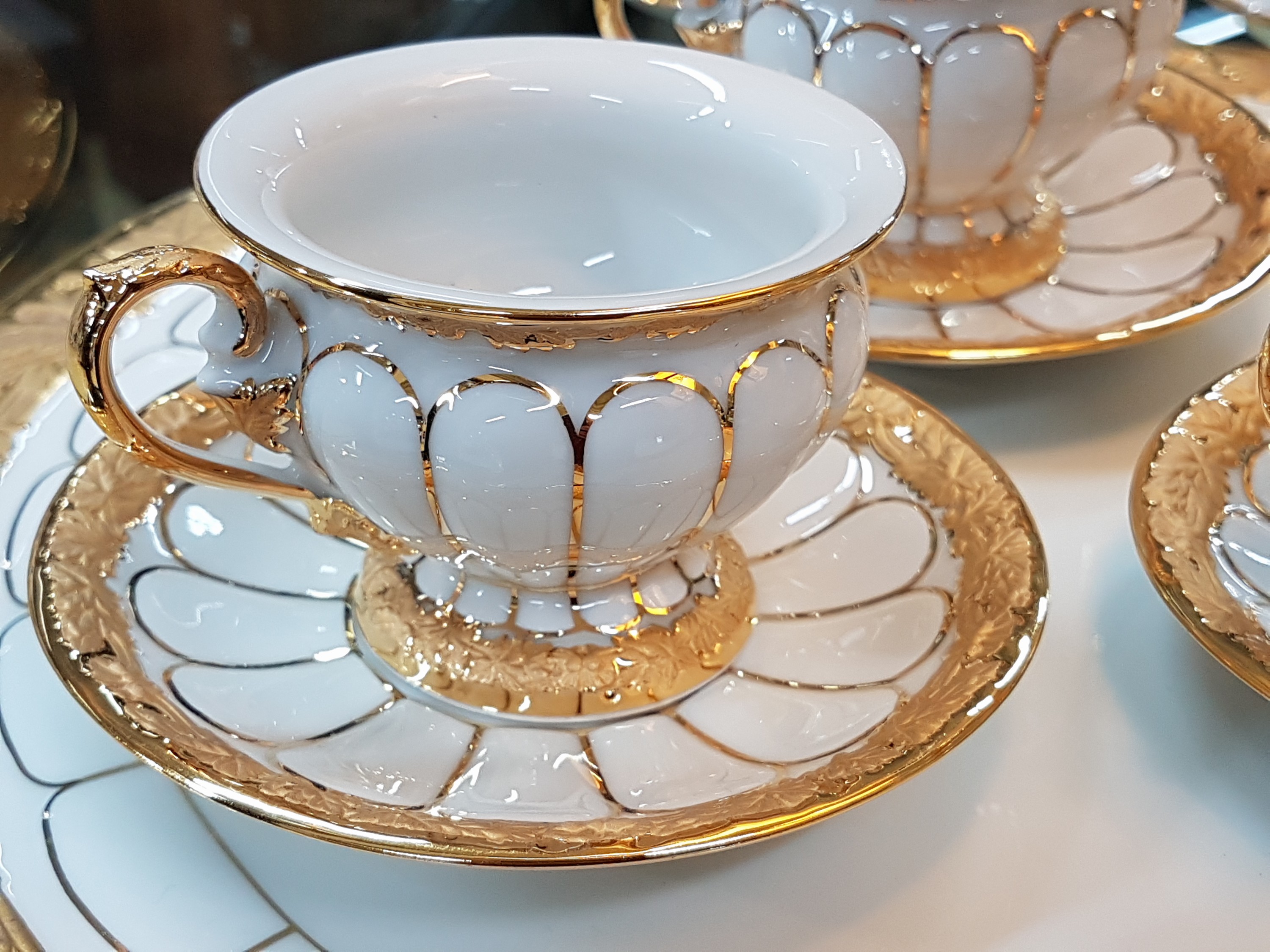 Detail c: 6 Mokkatassen und eine Kuchenplatte, Meissen, 20. Jh., 1. Wahl, X-Form, Relief matt- und glanzvergoldet, 6 Mokkatassen mit Untertassen, runde ...