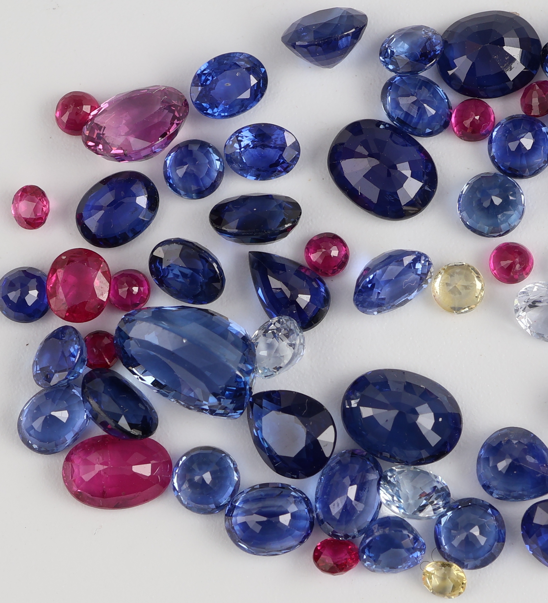 Detail b: Lot lose facett. Edelsteine, zus. 21.78 ct, überwiegend Saphire in versch. Farben und Formen, darunter auch Rubine