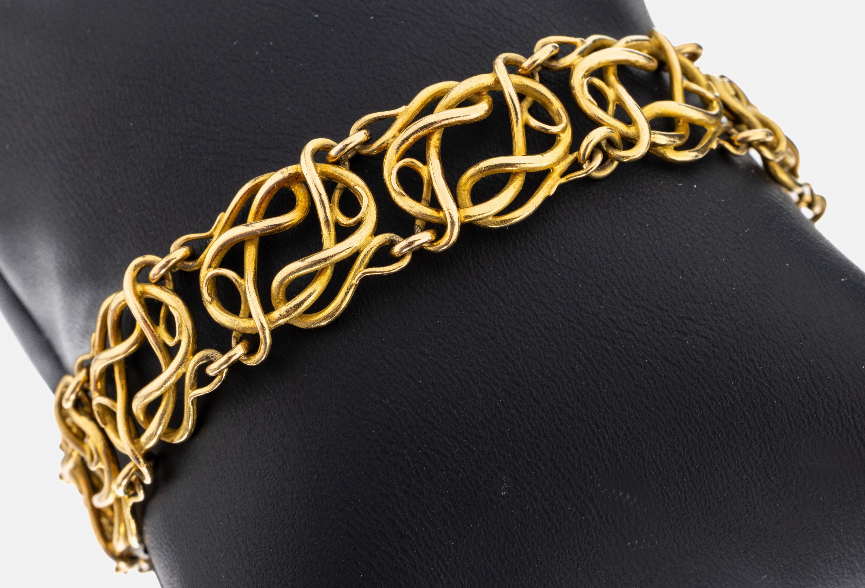 18 kt Gold Armband, GG 750/000, qualitätvolle Verarbeitung, ineinander verschlungene geschwungene Golddrähte, L. ca. 18.5 cm, Steckschließe mit ...