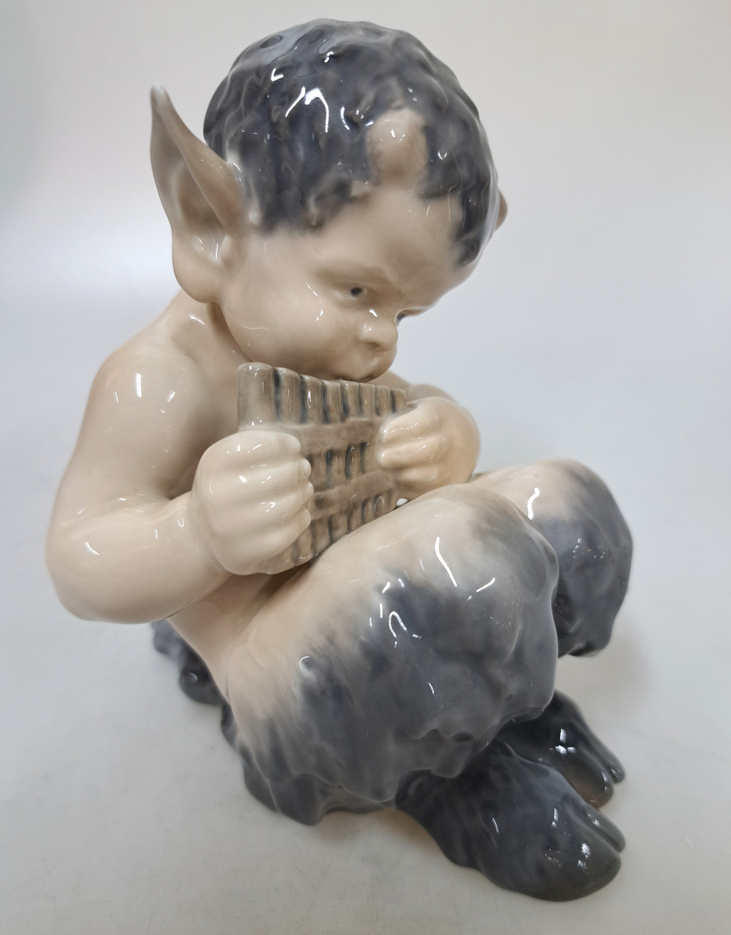 Detail h: Drei Porzellanfiguren, Royal Copenhagen, 20. Jh., Unterglasurbemalung, sitzender Faun mit Panflöte, H. ca. 13 cm, sitzender Faun mit Bär spielend, ...