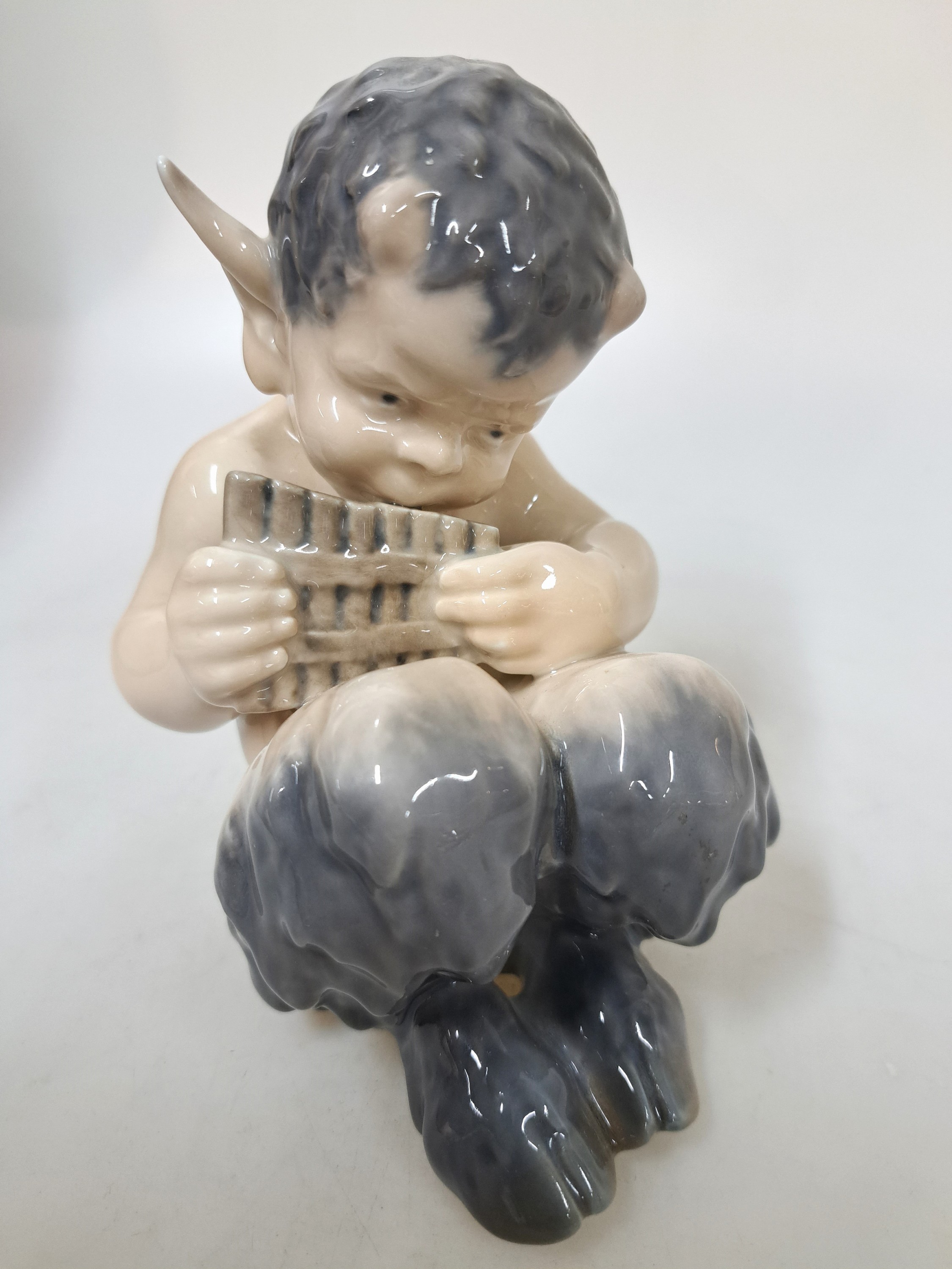Detail l: Drei Porzellanfiguren, Royal Copenhagen, 20. Jh., Unterglasurbemalung, sitzender Faun mit Panflöte, H. ca. 13 cm, sitzender Faun mit Bär spielend, ...