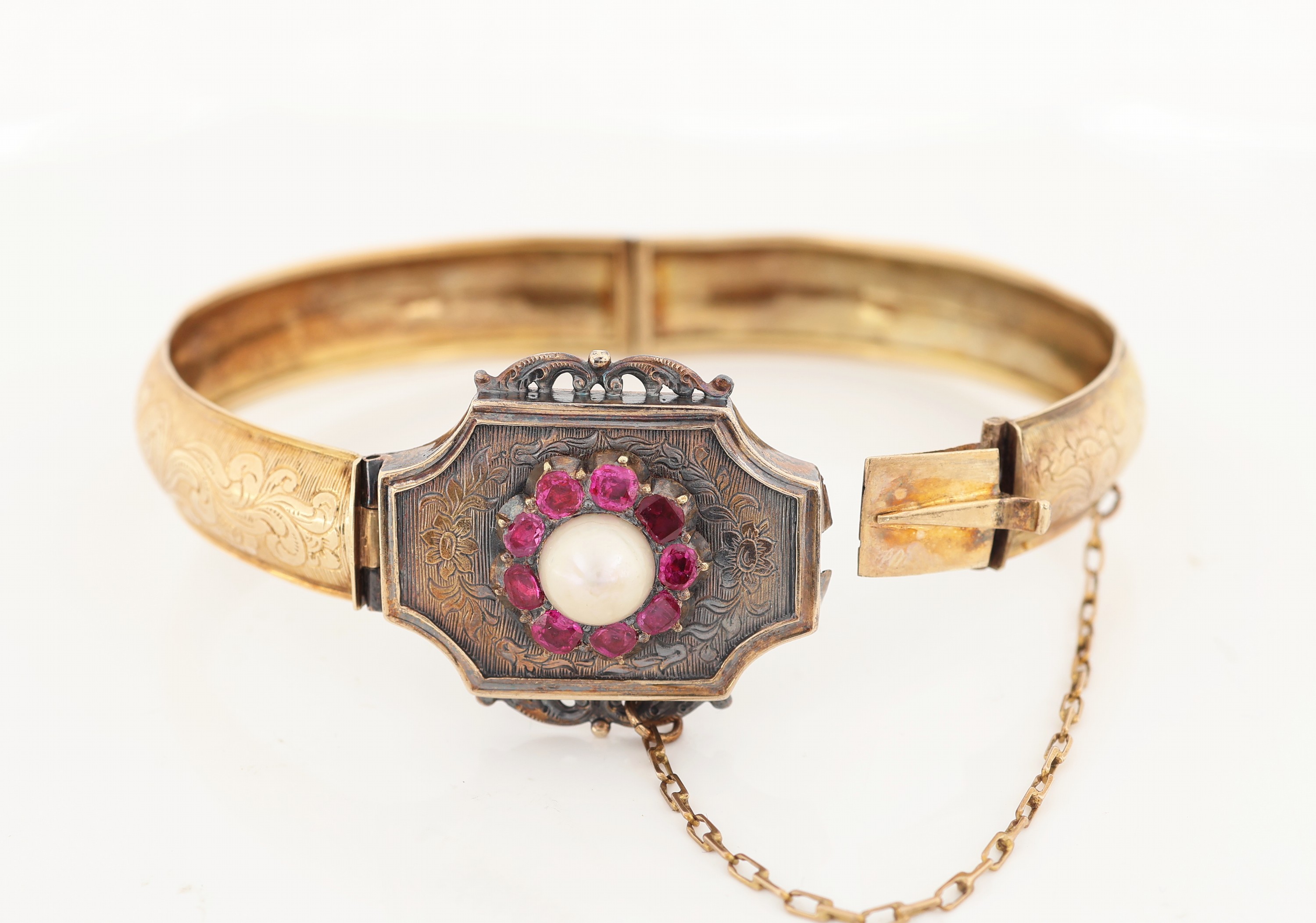 Detail a: 14 kt Gold Rubin-Armreif, um 1880/90, GG 585/000 und Silber, gepr., Mittelteil mit 9 Rubinen zus. ca. 0.40 ct, mittig Perle, Ziergravuren, ...