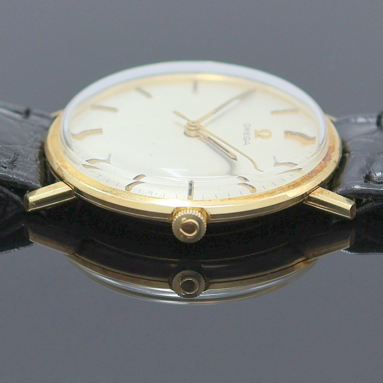 Detail d: OMEGA Herrenarmbanduhr in GG 750/000 Referenz 131016, Schweiz um 1965, Handaufzug, 2-tlg. Geh., Lünette aufgedr., silb. Zifferbl. pat., gold. ...