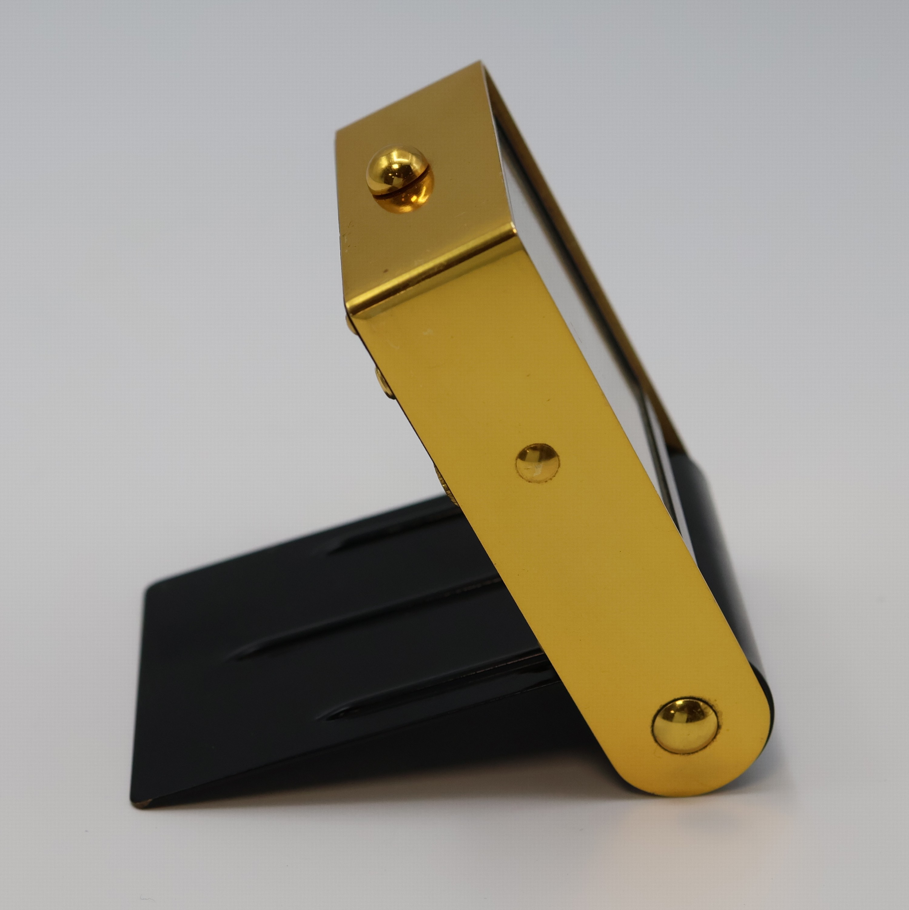 Detail b: JAEGER 2-Tage Reisewecker, Schweiz um 1950, schwarz lack. Geh., z. T. verg., aufstellbar durch Drehung des Glasschutzes, silb. Zifferbl., gold. ...
