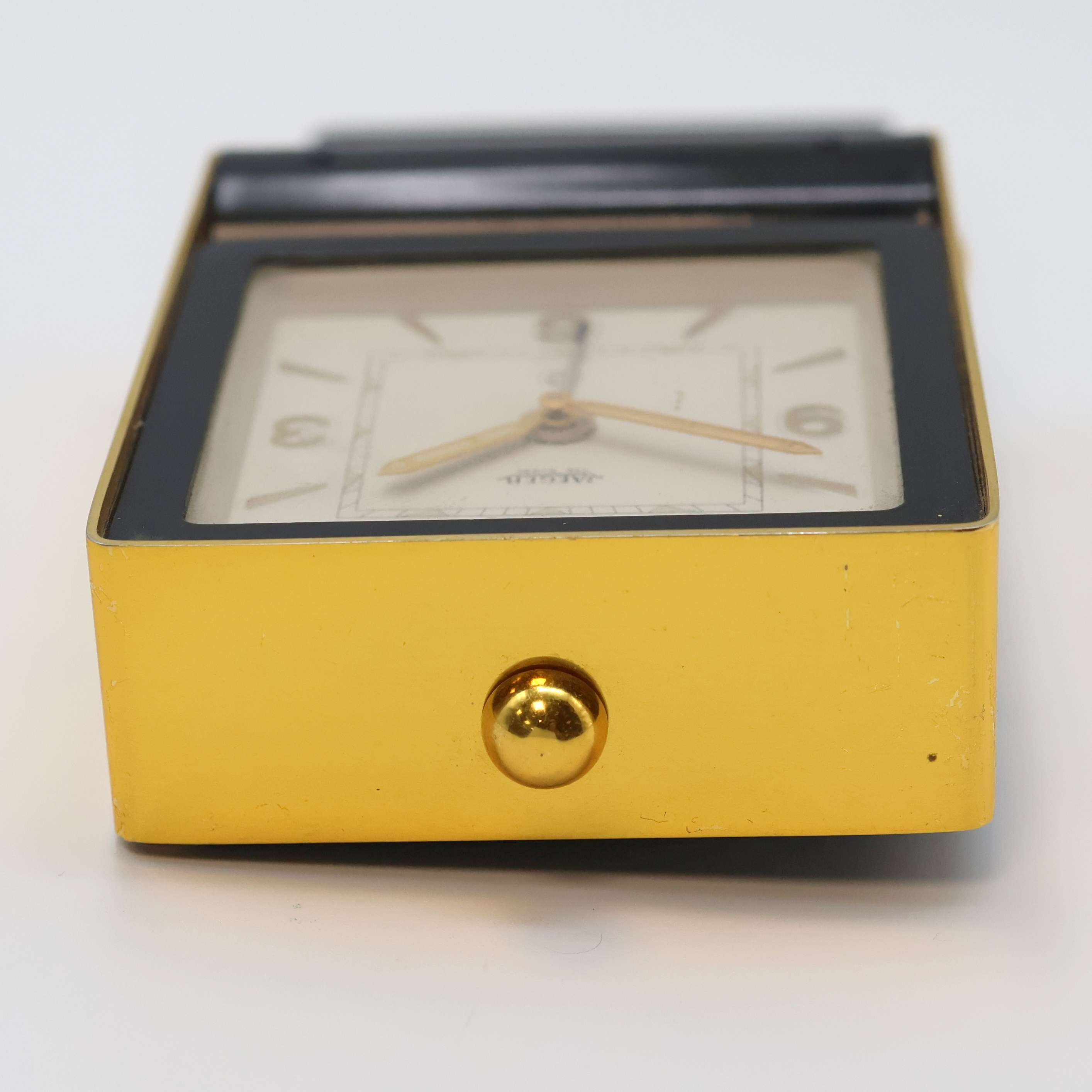 Detail c: JAEGER 2-Tage Reisewecker, Schweiz um 1950, schwarz lack. Geh., z. T. verg., aufstellbar durch Drehung des Glasschutzes, silb. Zifferbl., gold. ...