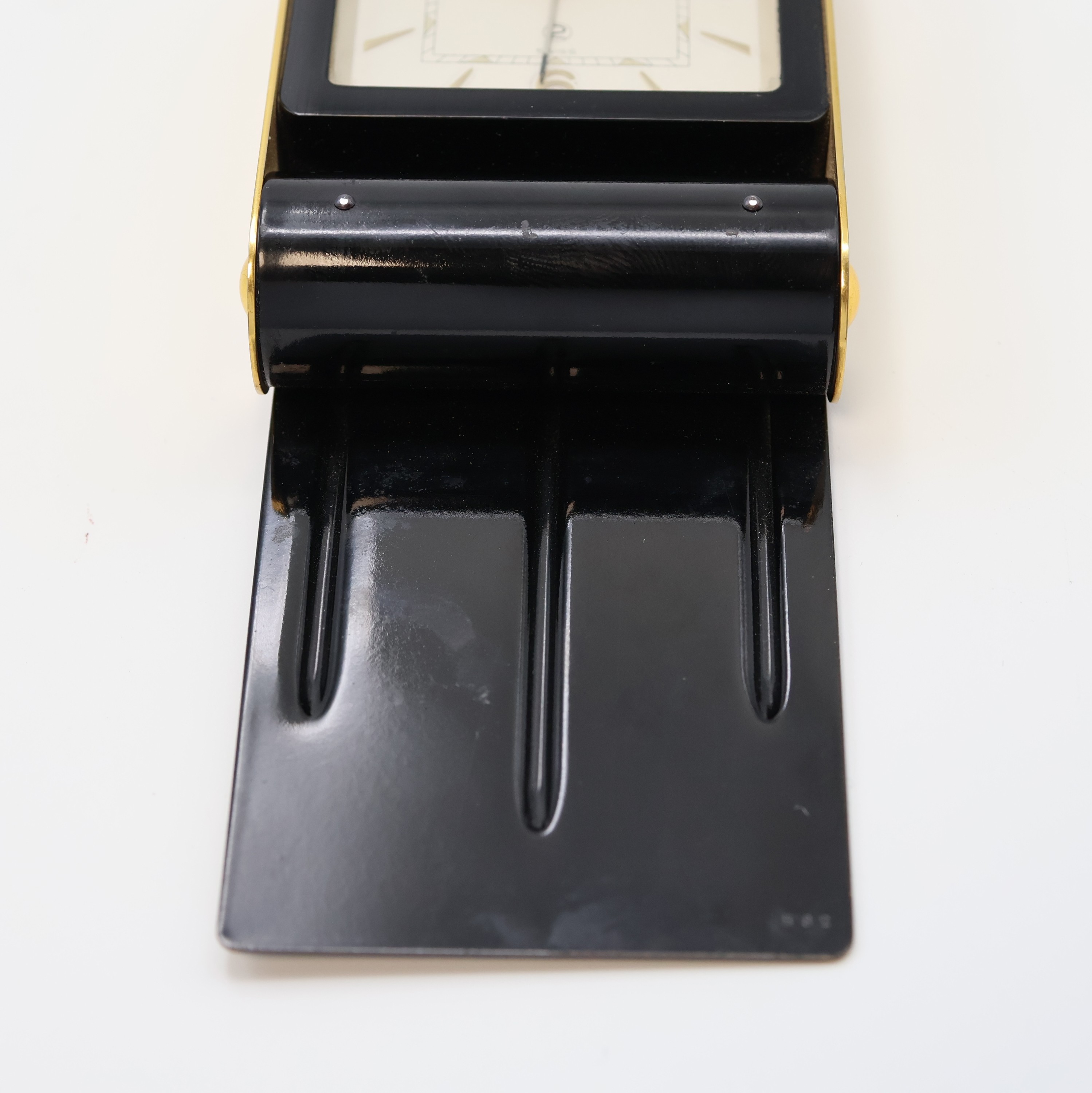 Detail d: JAEGER 2-Tage Reisewecker, Schweiz um 1950, schwarz lack. Geh., z. T. verg., aufstellbar durch Drehung des Glasschutzes, silb. Zifferbl., gold. ...