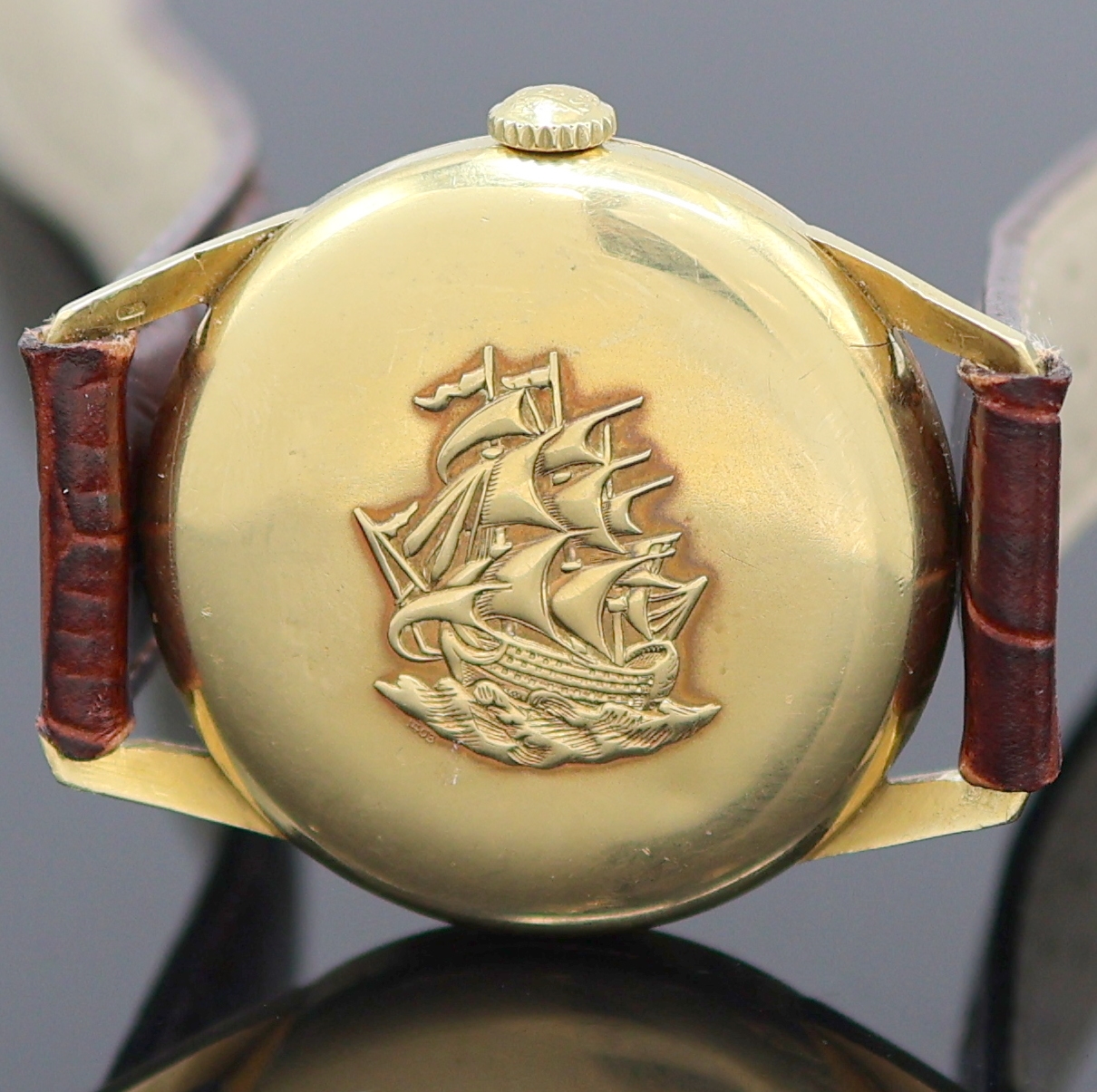 Detail e: LONGINES Flagship Herrenarmbanduhr in GG 750/000 Referenz 1403, Schweiz um 1965, Automatik, Boden m. Relief-Darst. eines Segelschiffs u. Glasrand ...