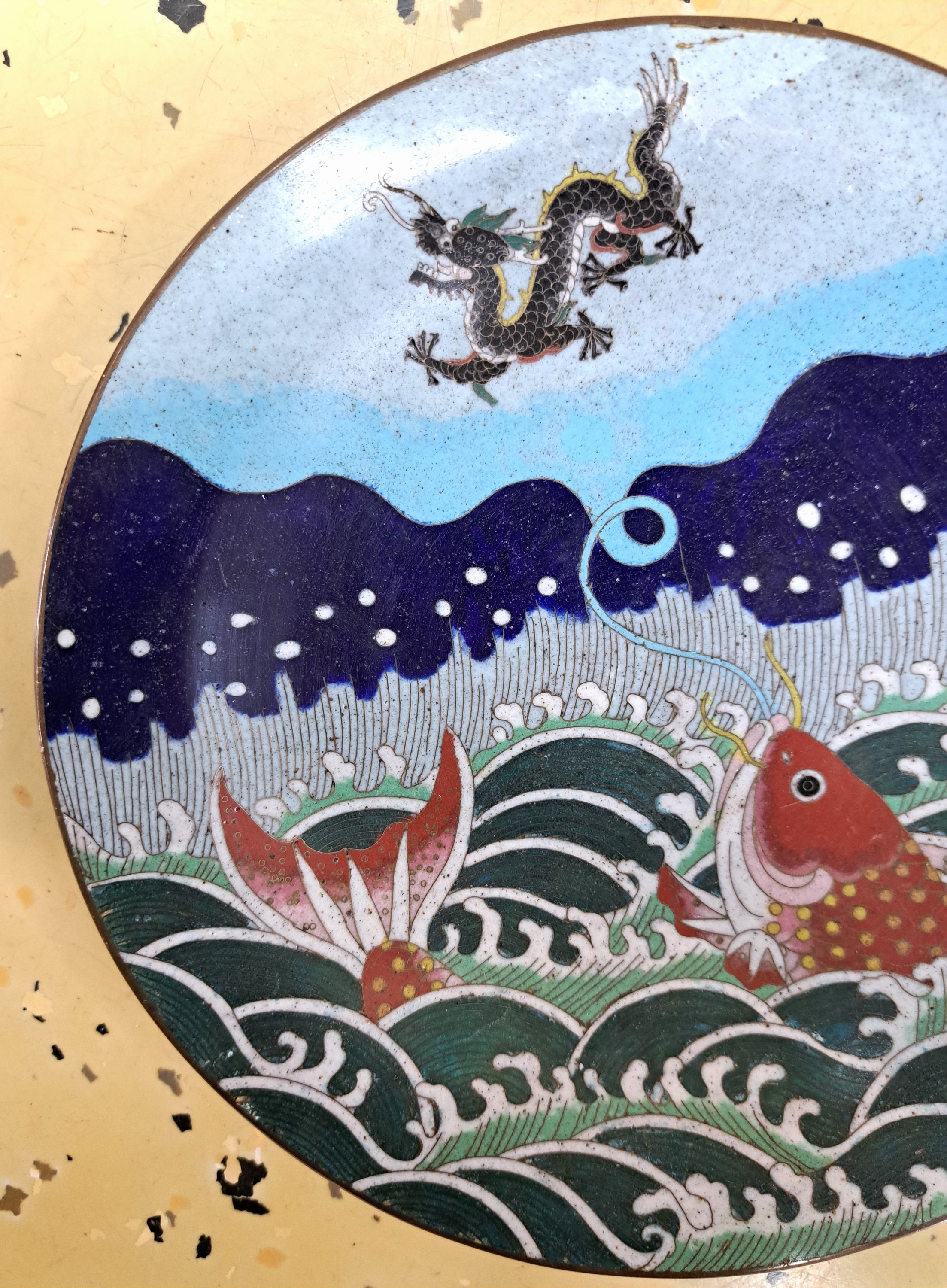 Detail c: Teller, Japan, um 1900, Bronze, fein bunt emailliert in Cloisonné-Technik, vorne mit Koi, Meer und Drache, Rückseite auf dem Rand mit umlaufendem ...