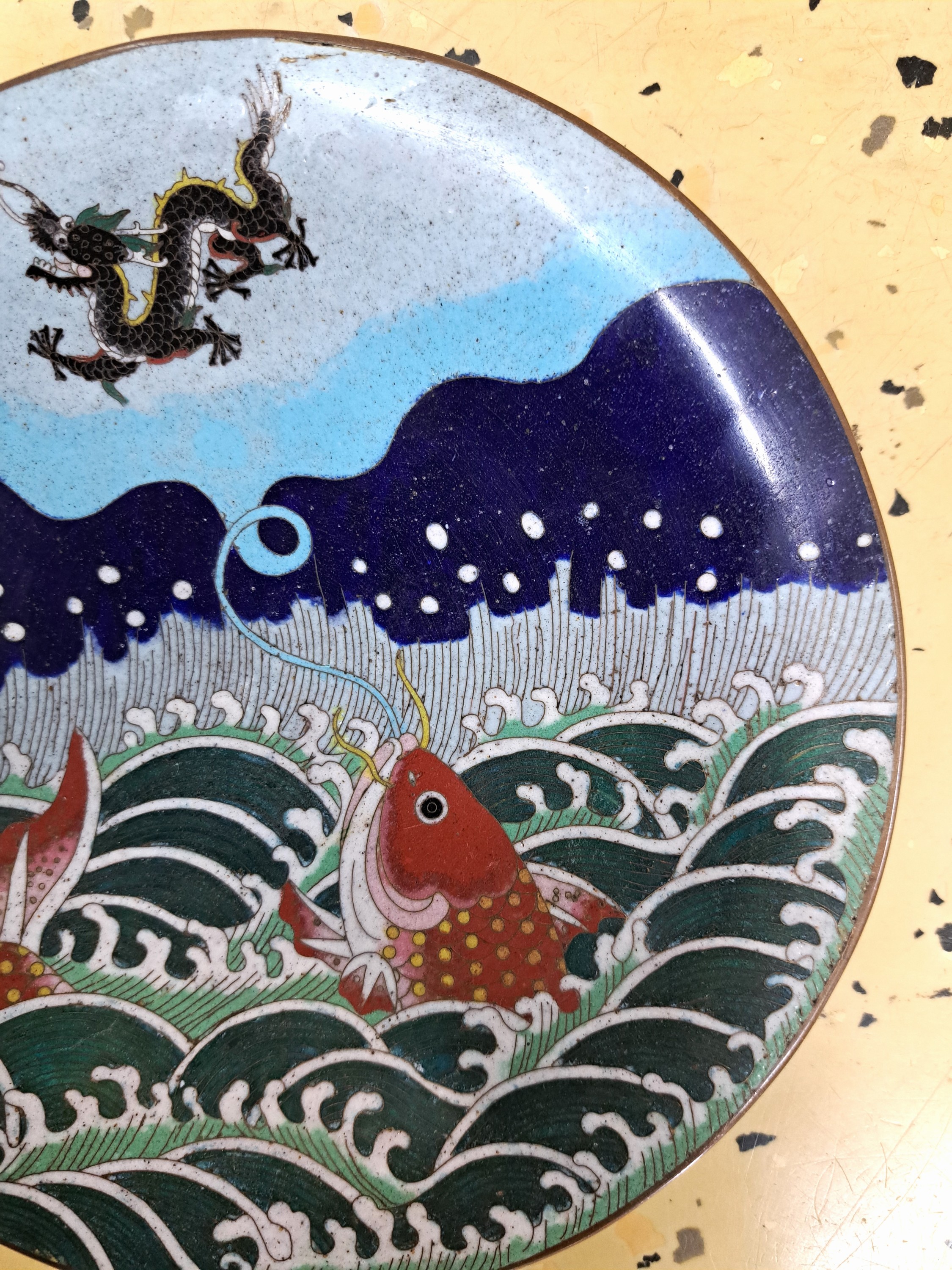 Detail d: Teller, Japan, um 1900, Bronze, fein bunt emailliert in Cloisonné-Technik, vorne mit Koi, Meer und Drache, Rückseite auf dem Rand mit umlaufendem ...