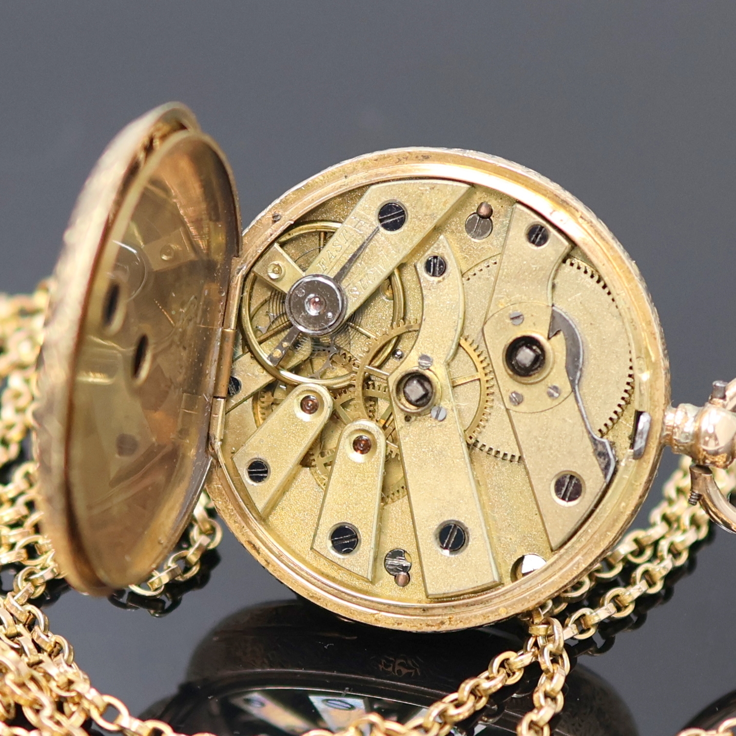 Detail e: Offene Zylinder-Damentaschenuhr in RoseG 585/000 an Kette in GG 585/000, Schweiz um 1895, reich graviertes Geh., Metallcuv., Emailzifferbl. m. röm. ...