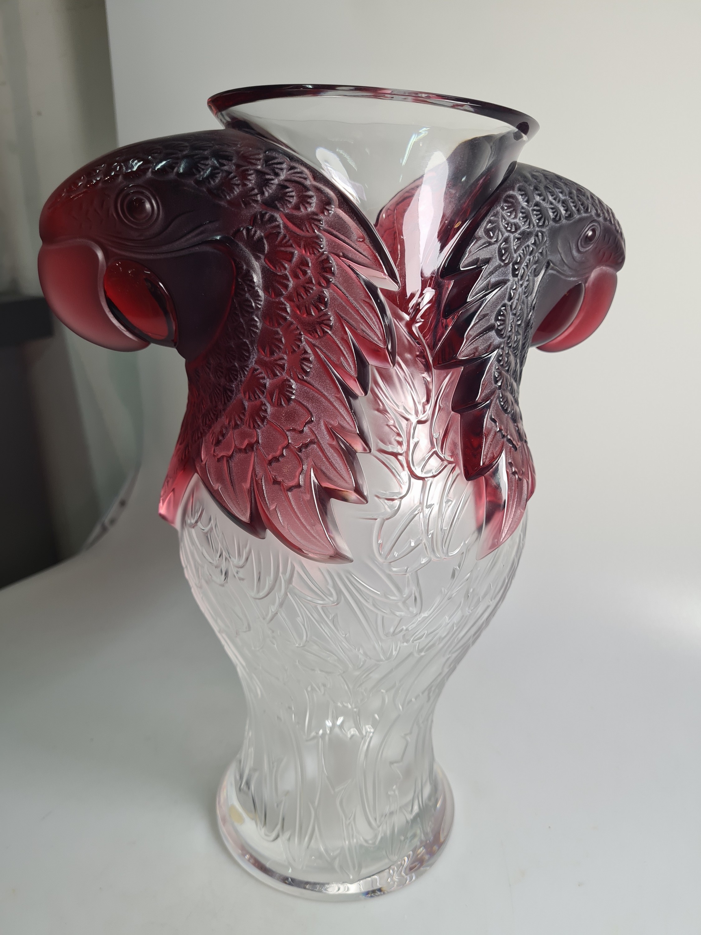 Detail c: Papageienvase, Lalique, 1990er-Jahre, am Boden signiert und nummeriert, Ed. 32/99, farbloses Glas z.T. dunkelrot gefärbt, Reliefdekor in Form von ...