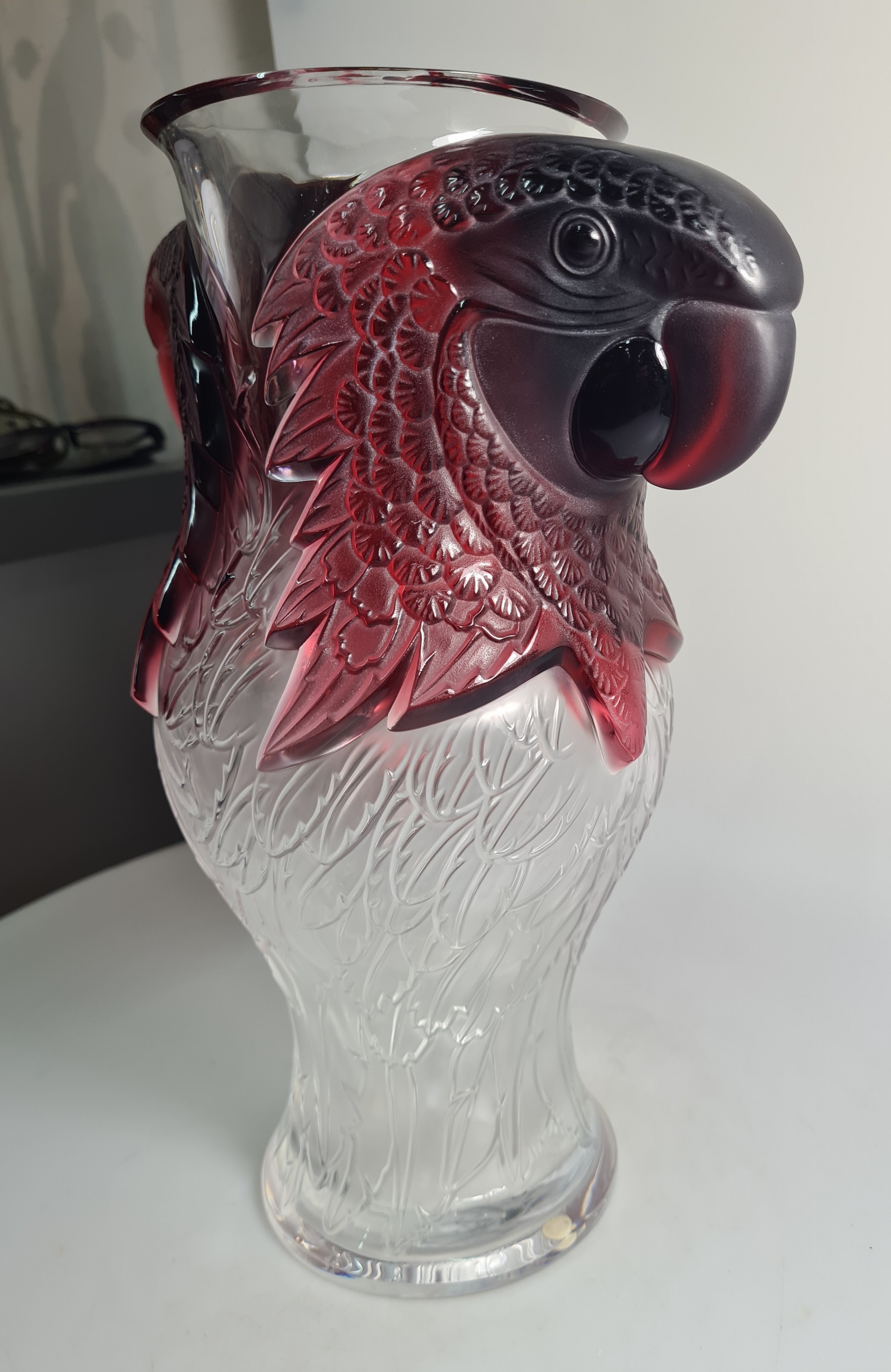 Detail d: Papageienvase, Lalique, 1990er-Jahre, am Boden signiert und nummeriert, Ed. 32/99, farbloses Glas z.T. dunkelrot gefärbt, Reliefdekor in Form von ...