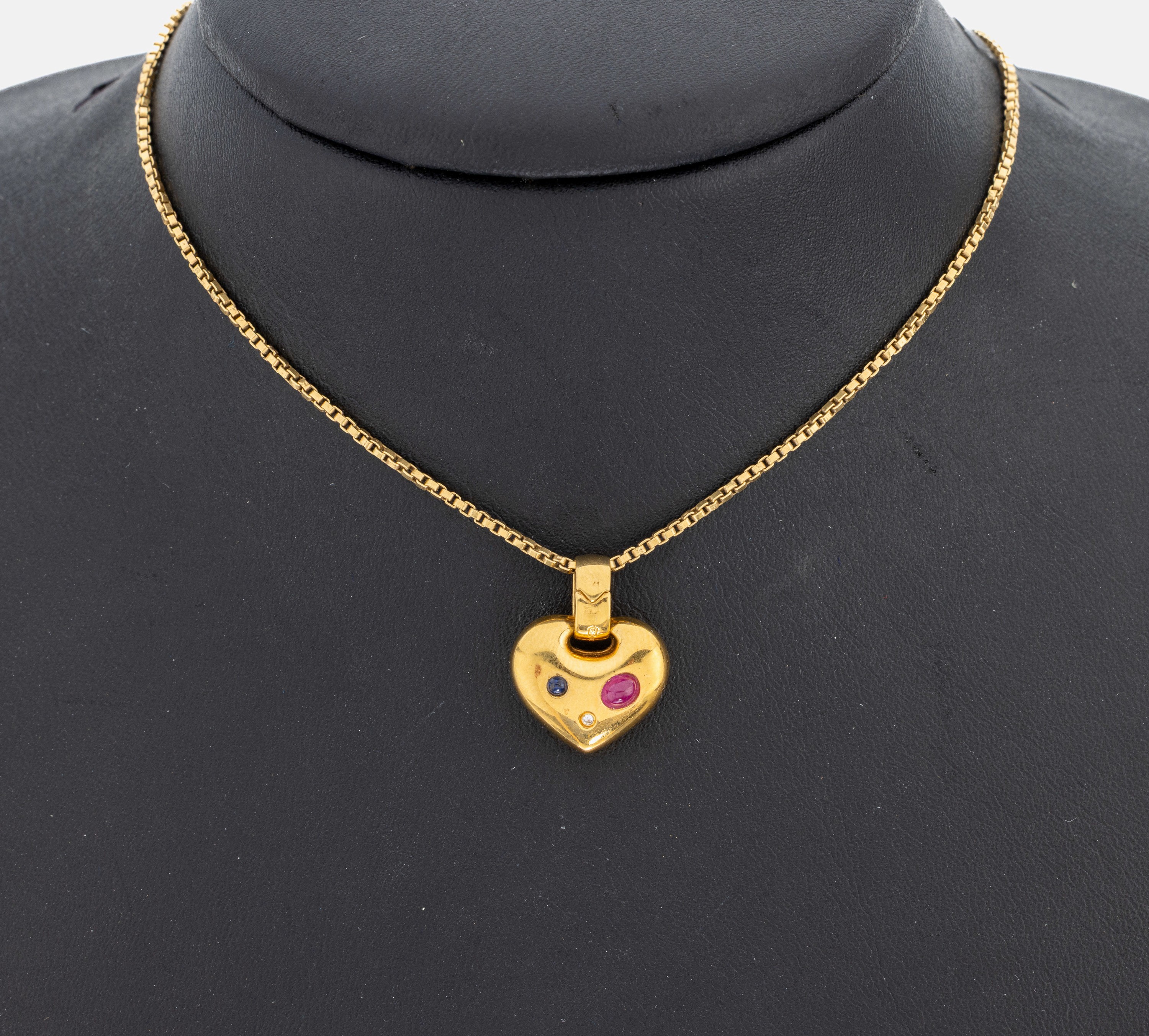 18 kt Gold Rubin-Saphir-Brillant-Anhänger, GG 750/000, schlichtes Herz, ovaler Rubin- Cabochon und runder Saphir-Cabochon zus. ca. 0.10 ct, ...