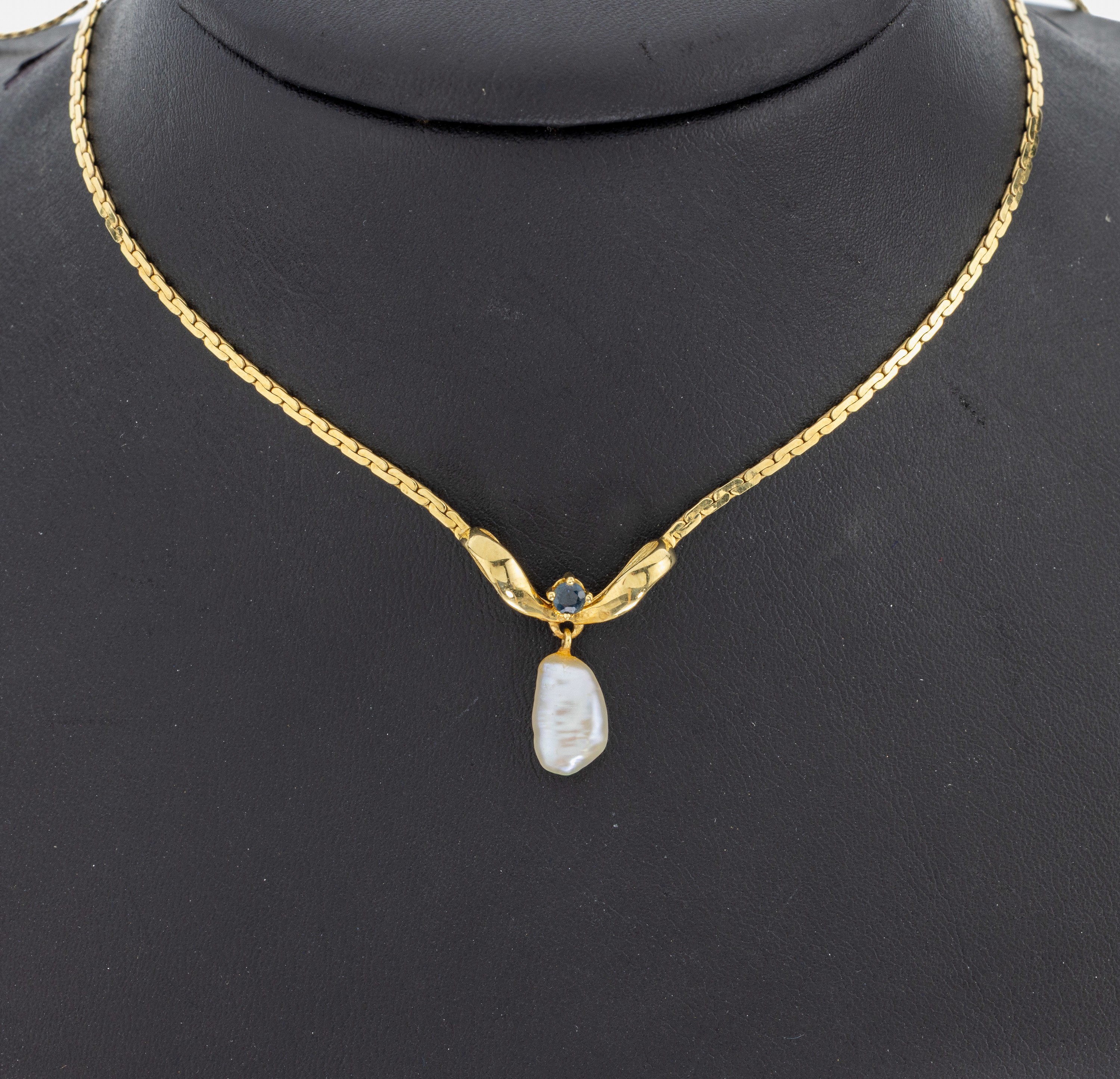 14 kt Gold Perl-Saphir-Collier, GG 585/000,schleifenf. Mittelteil, bewegl. abgehängte unrunde Zuchtperle, 1 kl. rundfacett. Saphir, L. ca. 40 cm, ...