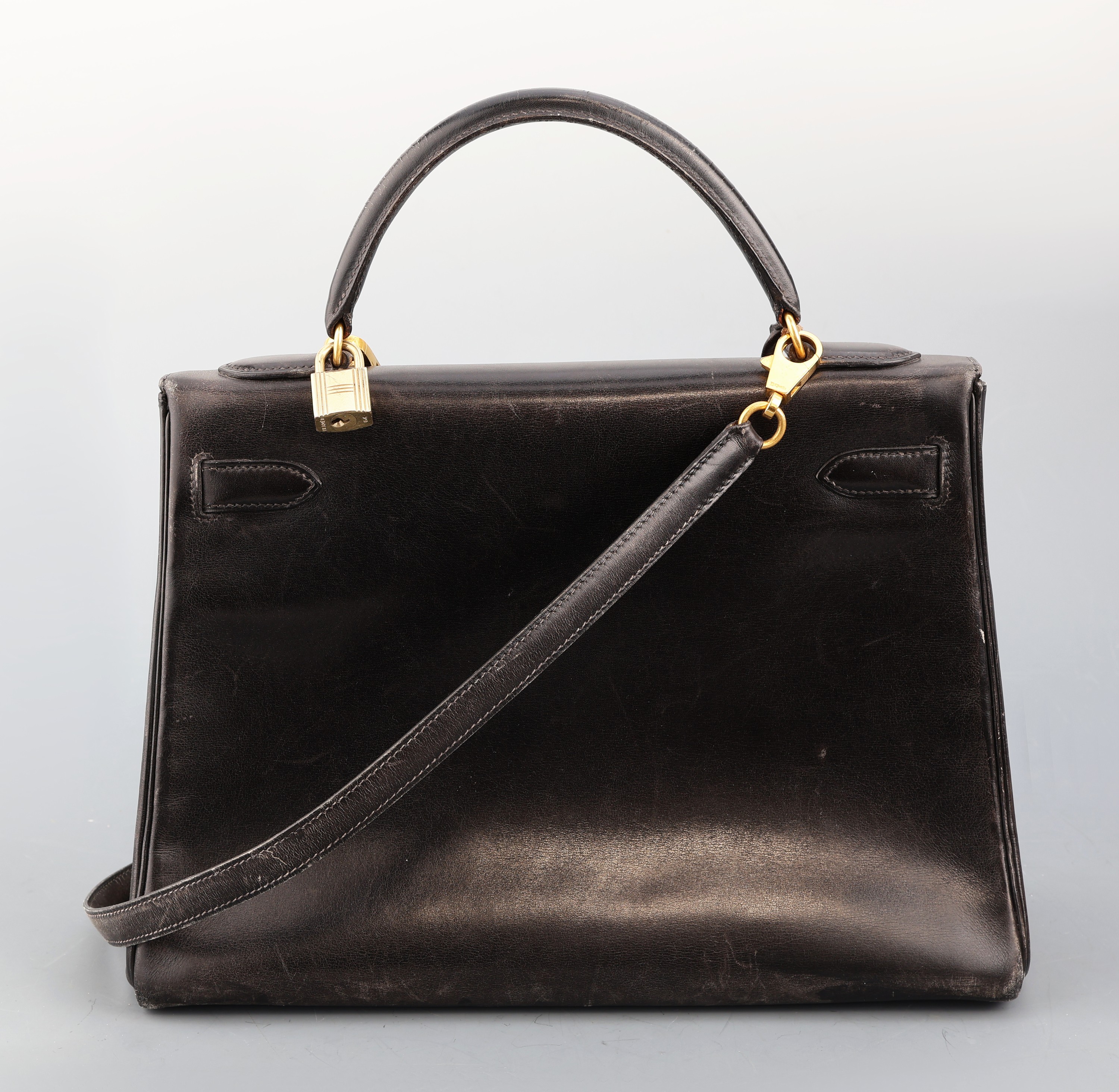 Detail a: HERMES Kelly Bag, schwarzes Glatt-Leder, 1992, goldfarb. Hardware, Schloss mit Clochette und Schlüssel, Umhängeriemen. ca. 31 x 11.5 x 22 cm, ...