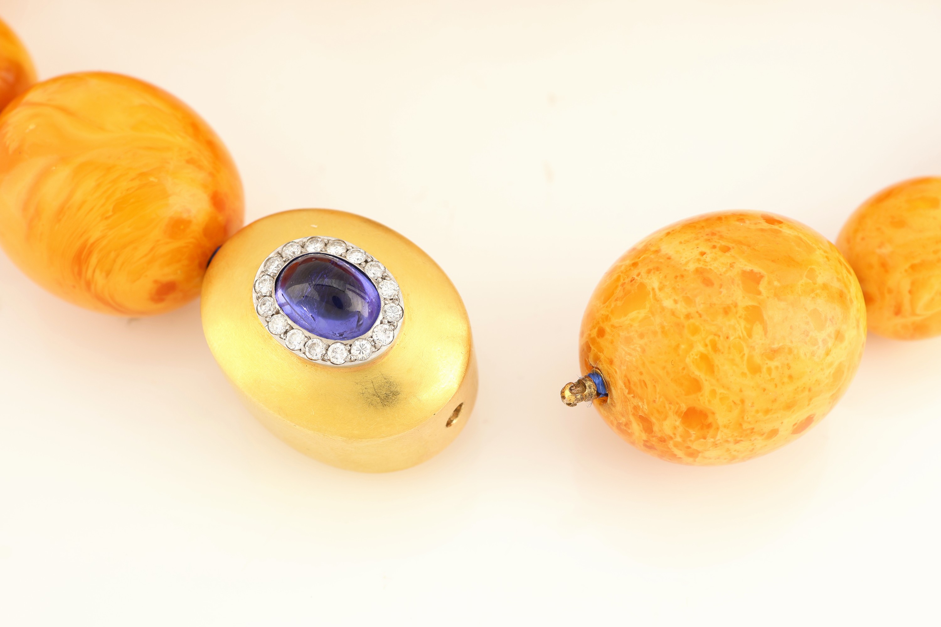 Detail b: Ausgefallenes Bernstein-Collier mit 18 kt Goldund Platin Tansanit-Brillant-Schließe, GG 750/000 und Pt 950/000, gr. Bernstein-Oliven in versch. ...
