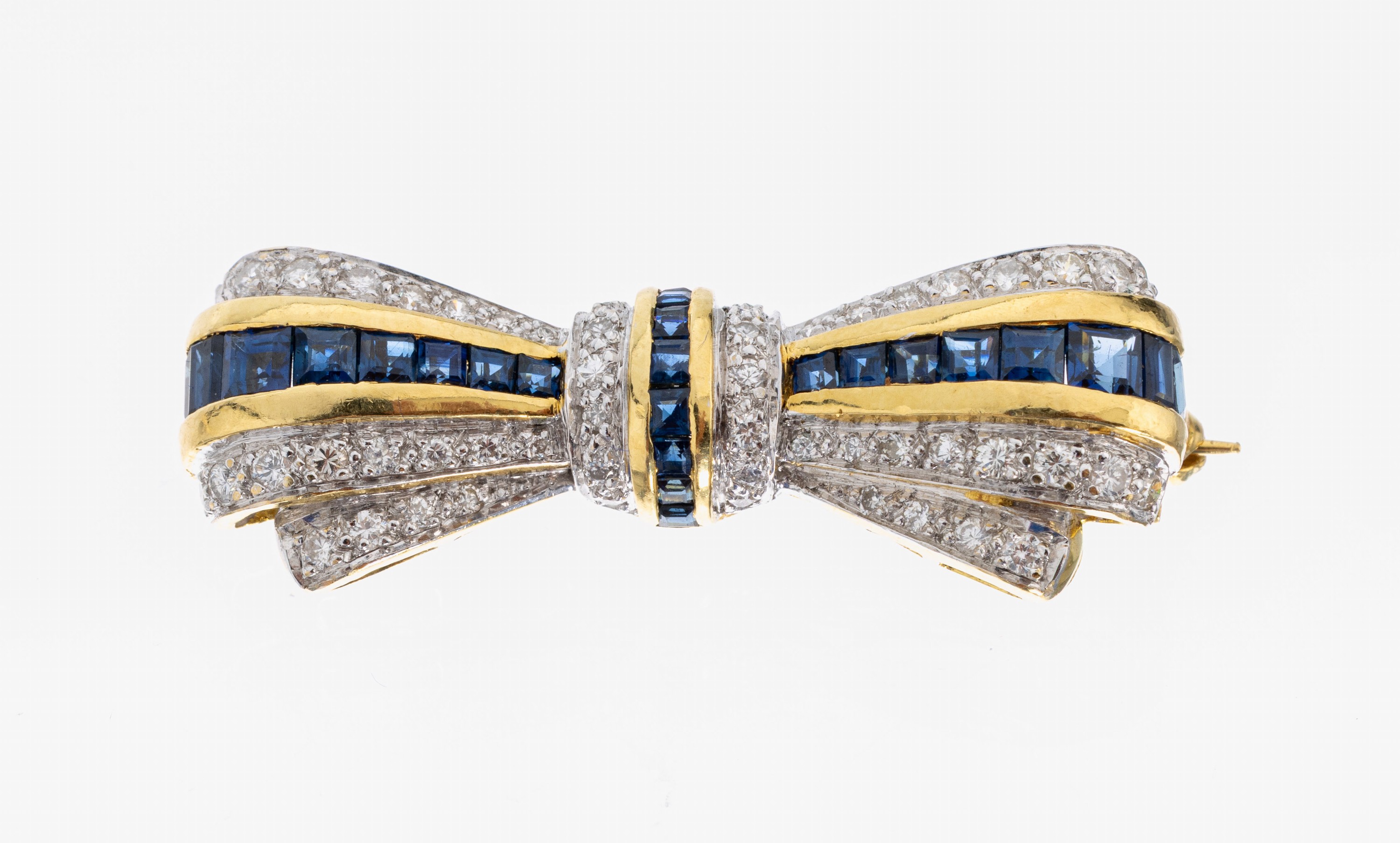 18 kt Gold Saphir-Brillant-Brosche, GG/WG 750/000 gepr., Darstellung einer Schleife, 25 Saphir-Carrees zus. ca. 1.0 ct, 53 Brillanten zus. ca. 0.60 ...