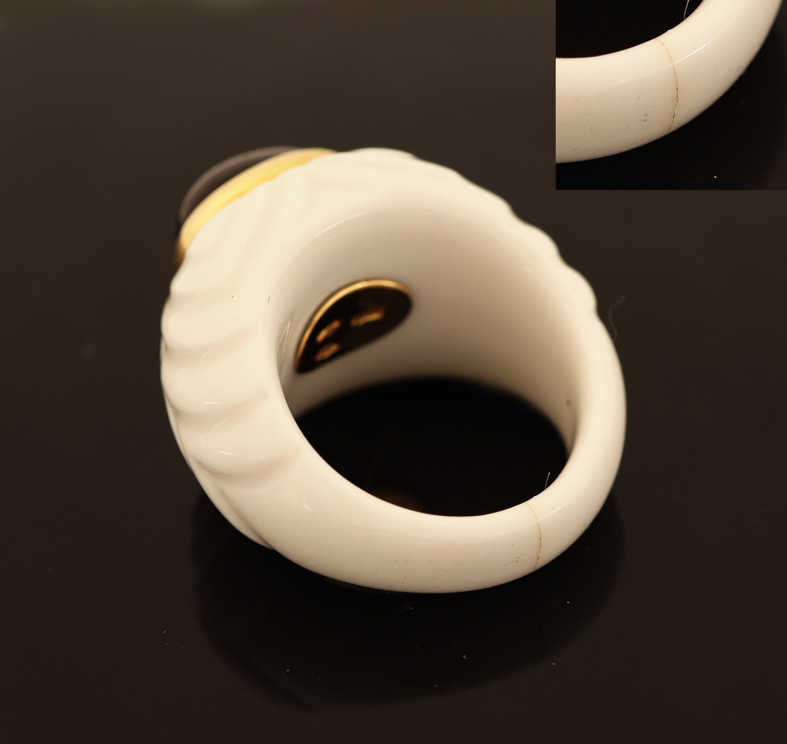 Detail b: BULGARI Rubellit-Ring, Modell CHANDRA, weiße Keramikschiene (untere Mitte mit Riss), ovaler Rubellit-Cabochon ca. 2.50 ct, in GG 750/000 Fassung, ...