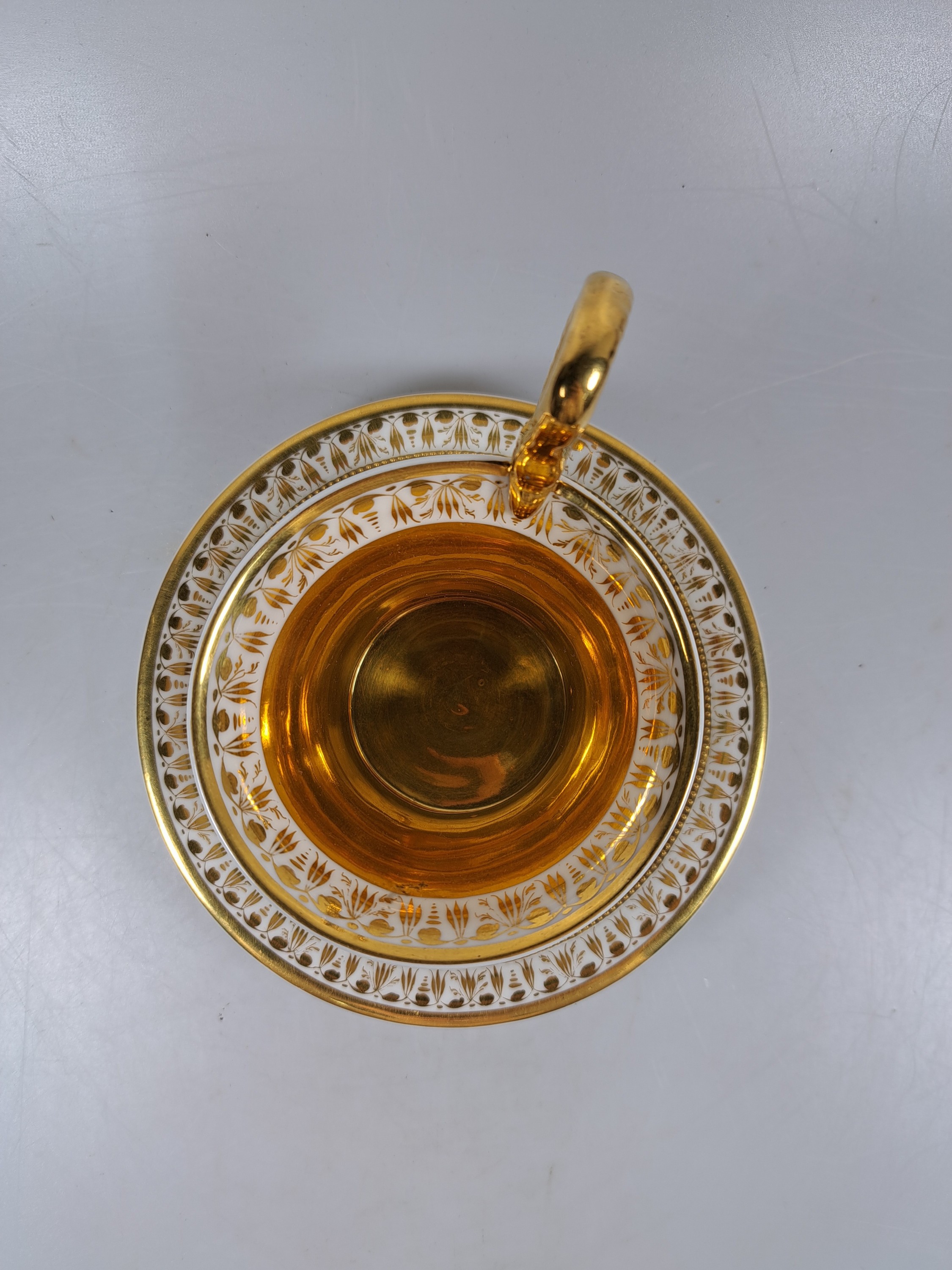 Detail b: Empiretasse mit Untertasse, KPM Berlin, um 1800, Porzellan, umlaufende bemalte Blumengirlande, reiche Goldstaffage und Goldbordüren, Perlränder, ...