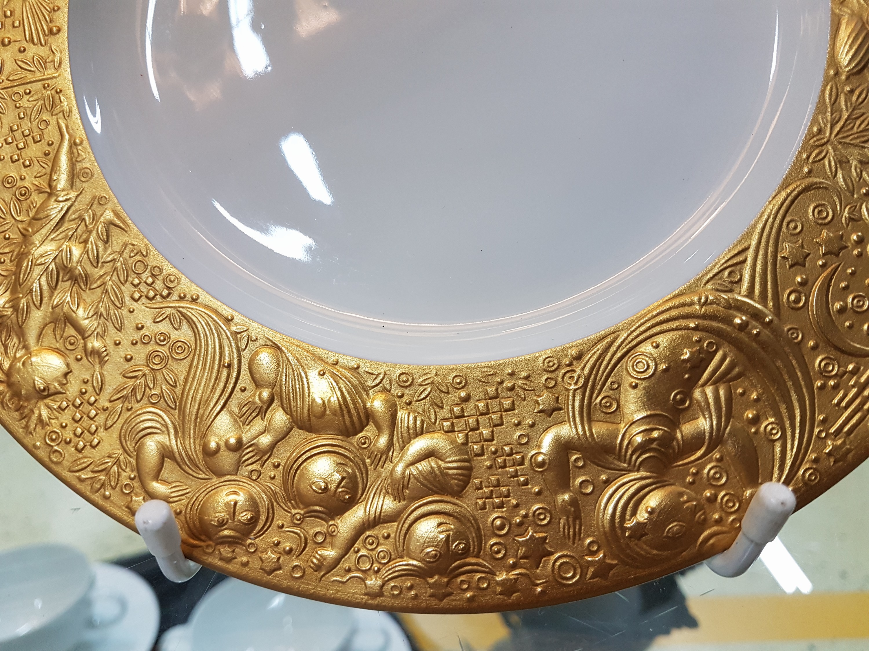 Detail d: 11 Teller, Rosenthal, Dekor Zauberflöte Sarasto, Entwurf Björn Wiinblad, reich reliefiert und teilvergoldet, D. je ca. 22cm