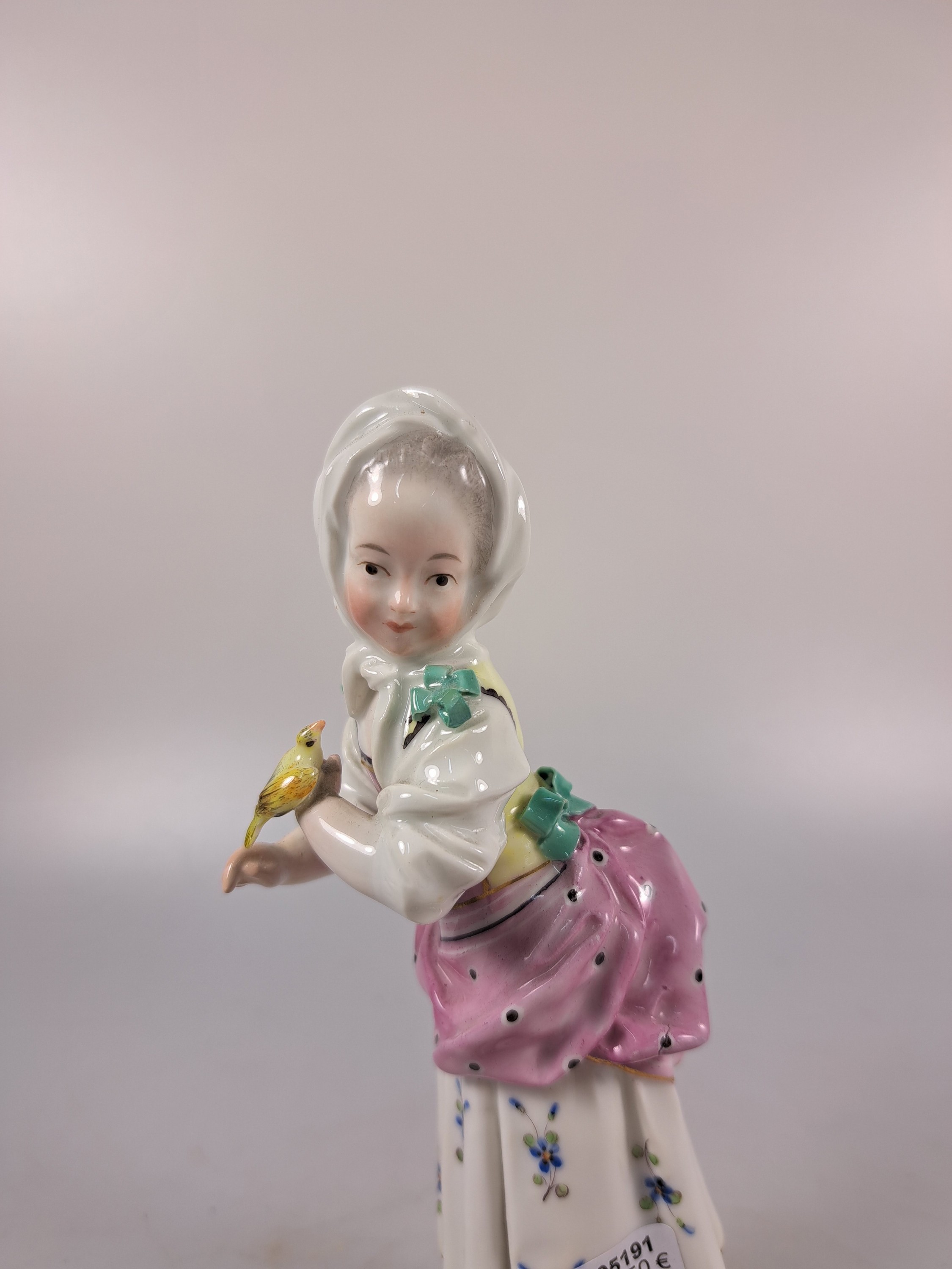 Detail b: Porzellanfigur, Höchst, um 1770, Mädchen mit Kopftuch und Vogel, bunt bemalt, restauriert, H. 18.3 cm