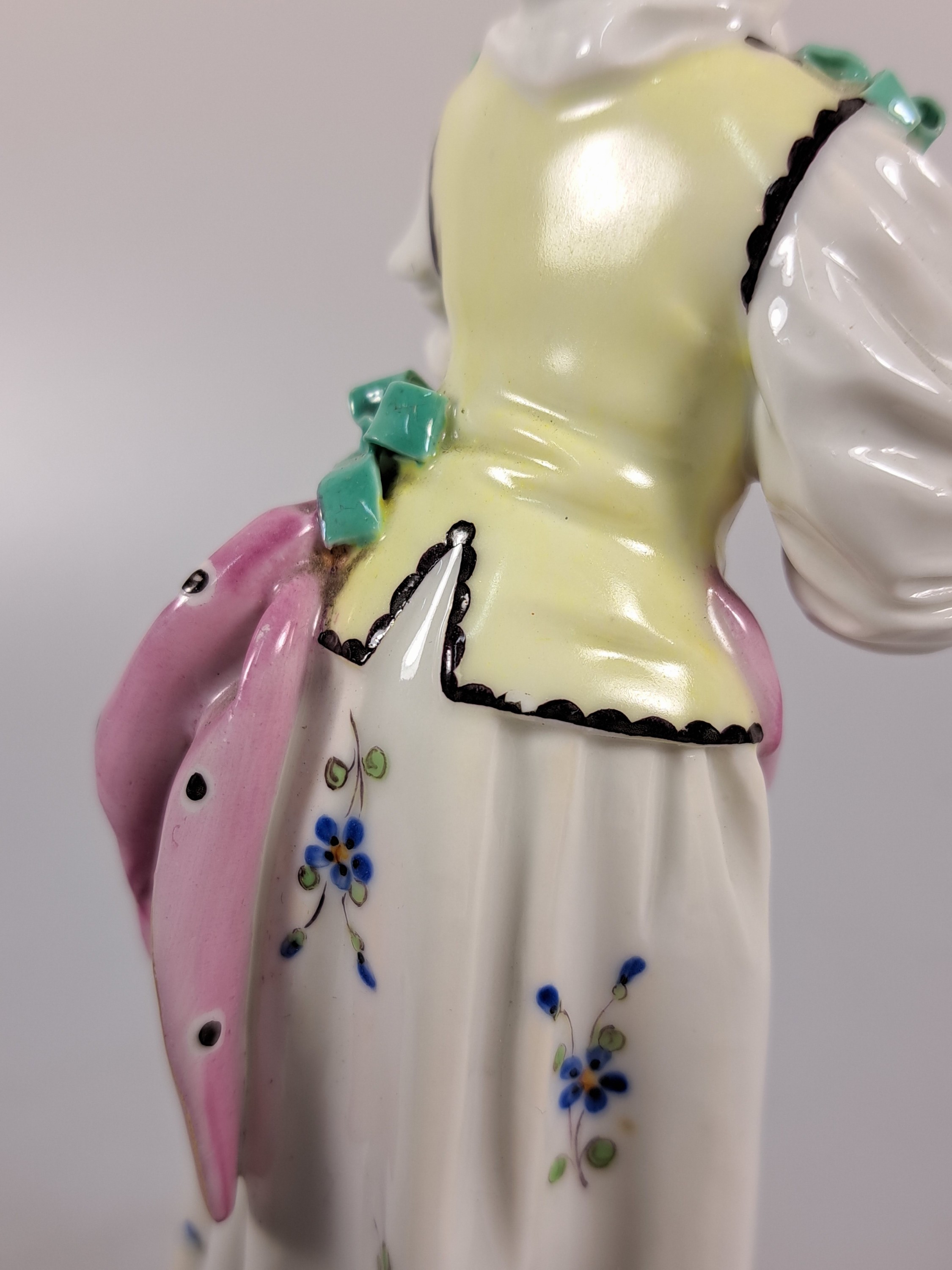 Detail g: Porzellanfigur, Höchst, um 1770, Mädchen mit Kopftuch und Vogel, bunt bemalt, restauriert, H. 18.3 cm