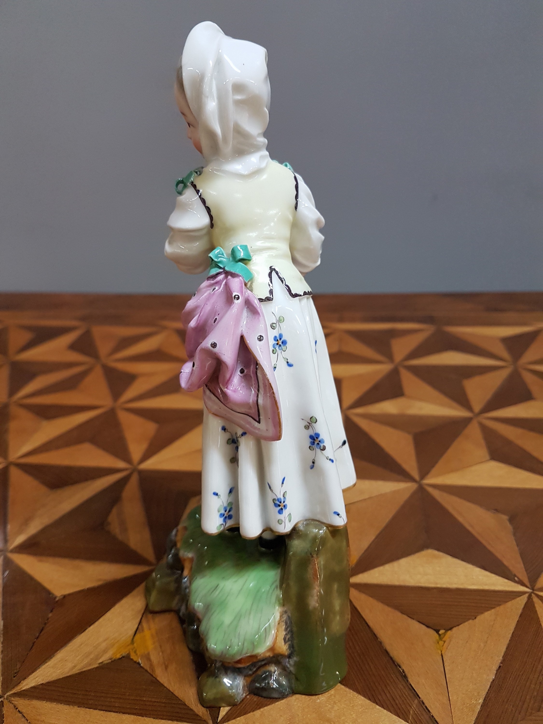 Detail m: Porzellanfigur, Höchst, um 1770, Mädchen mit Kopftuch und Vogel, bunt bemalt, restauriert, H. 18.3 cm