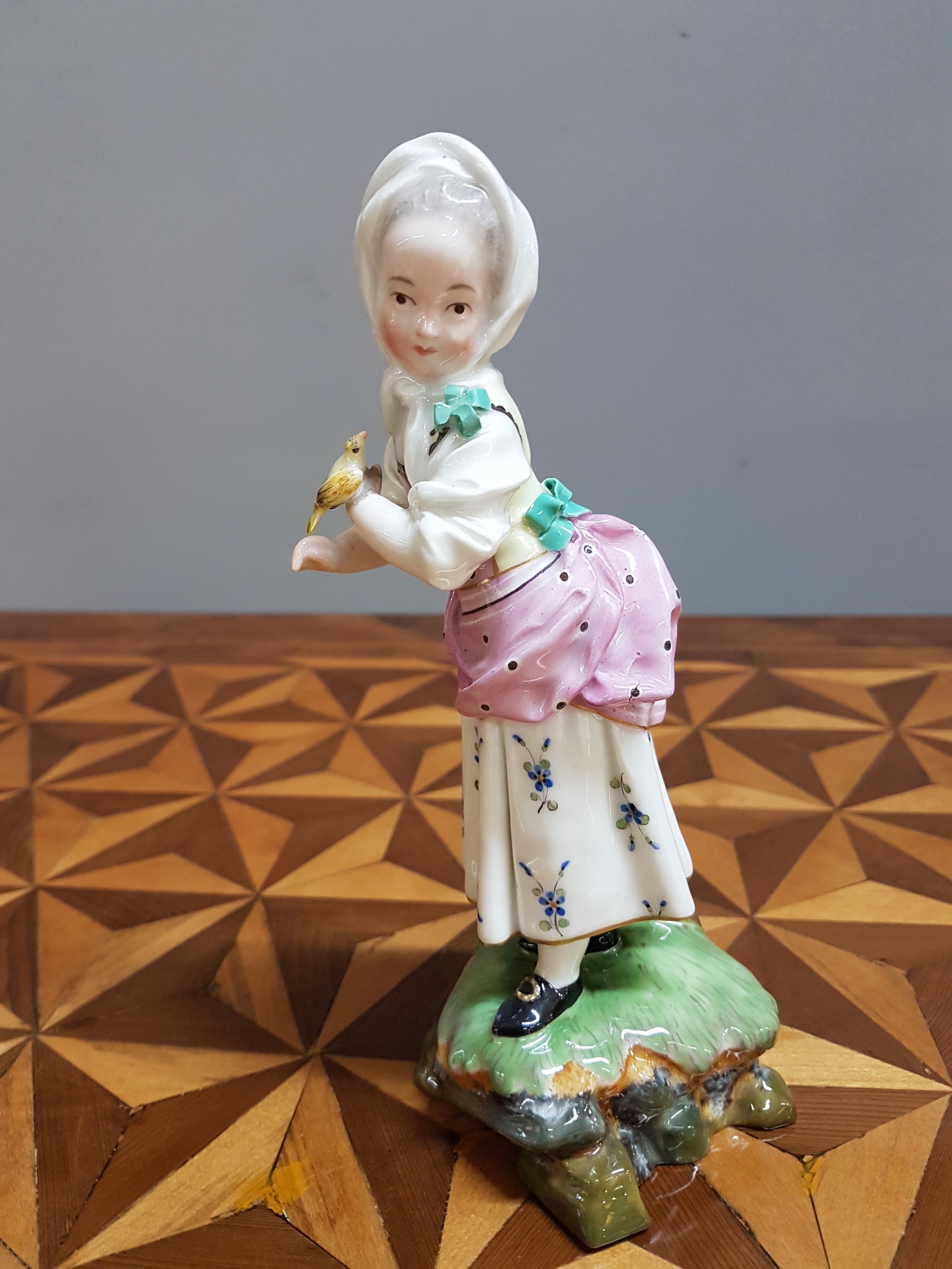 Detail n: Porzellanfigur, Höchst, um 1770, Mädchen mit Kopftuch und Vogel, bunt bemalt, restauriert, H. 18.3 cm
