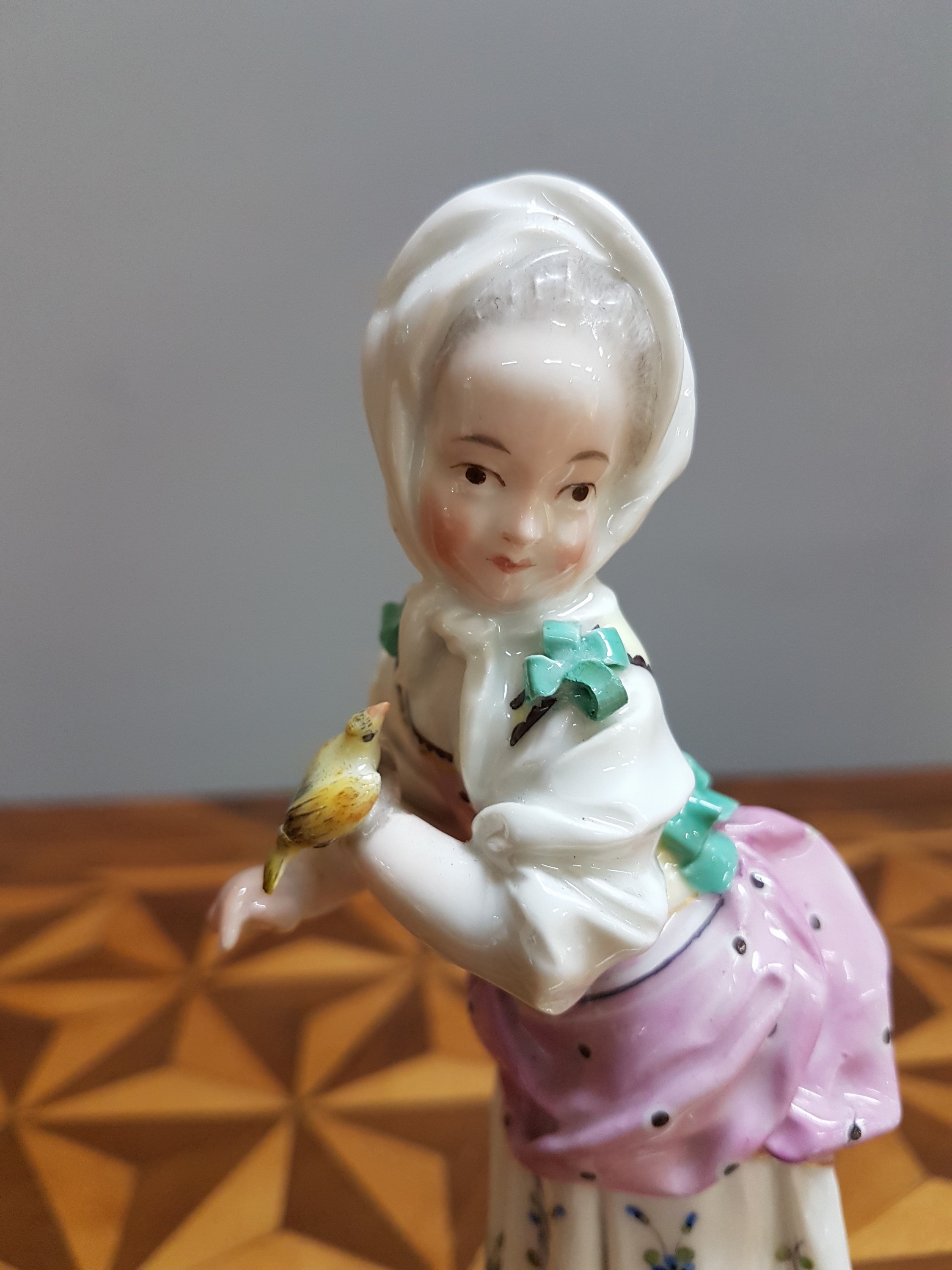 Detail o: Porzellanfigur, Höchst, um 1770, Mädchen mit Kopftuch und Vogel, bunt bemalt, restauriert, H. 18.3 cm