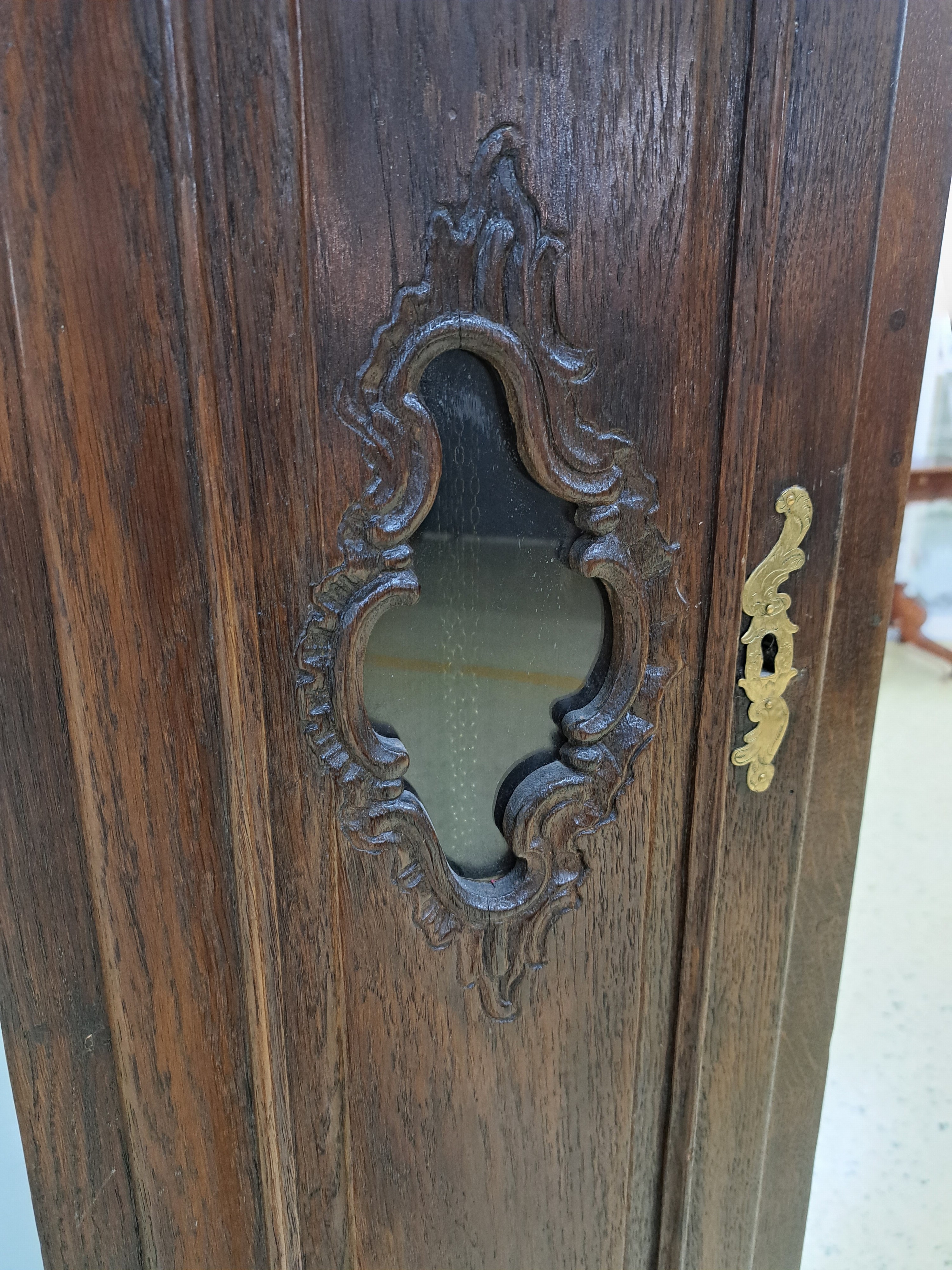 Detail d: Standuhr, deutsch, um 1760/80, Eichengehäuse mit kräftigen Schnitzarbeiten, geschnitzte Rokoko-Elemente, Kopf abnehmbar, an oberer Tür Abplatzer ...