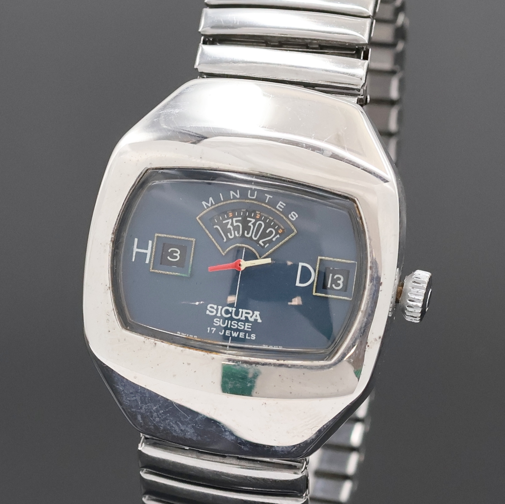 Detail a: SICURA Herrenarmbanduhr mit springender Stunde, Schweiz um 1970, Handaufzug, verchr. Geh., Stahlboden verschr., neutr. Flexband, blaues Zifferbl., ...