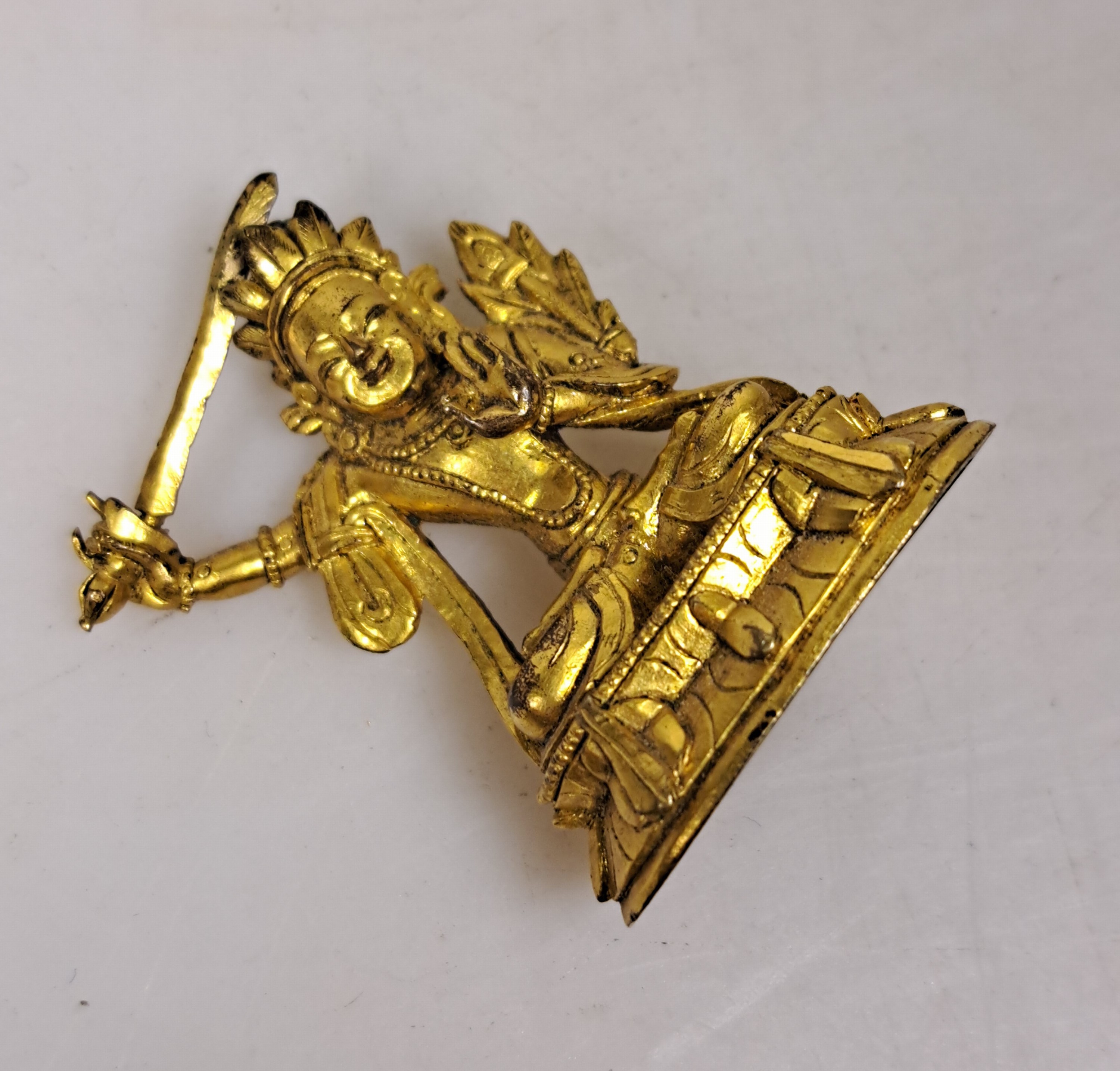 Detail d: Miniatur eines Manjushri, wohl Tibet, um 1880, mit Echtvergoldung, detaillierte, feine Ausarbeitung, doppelter Lotus, Sockel, H. ca. 4cm, ...