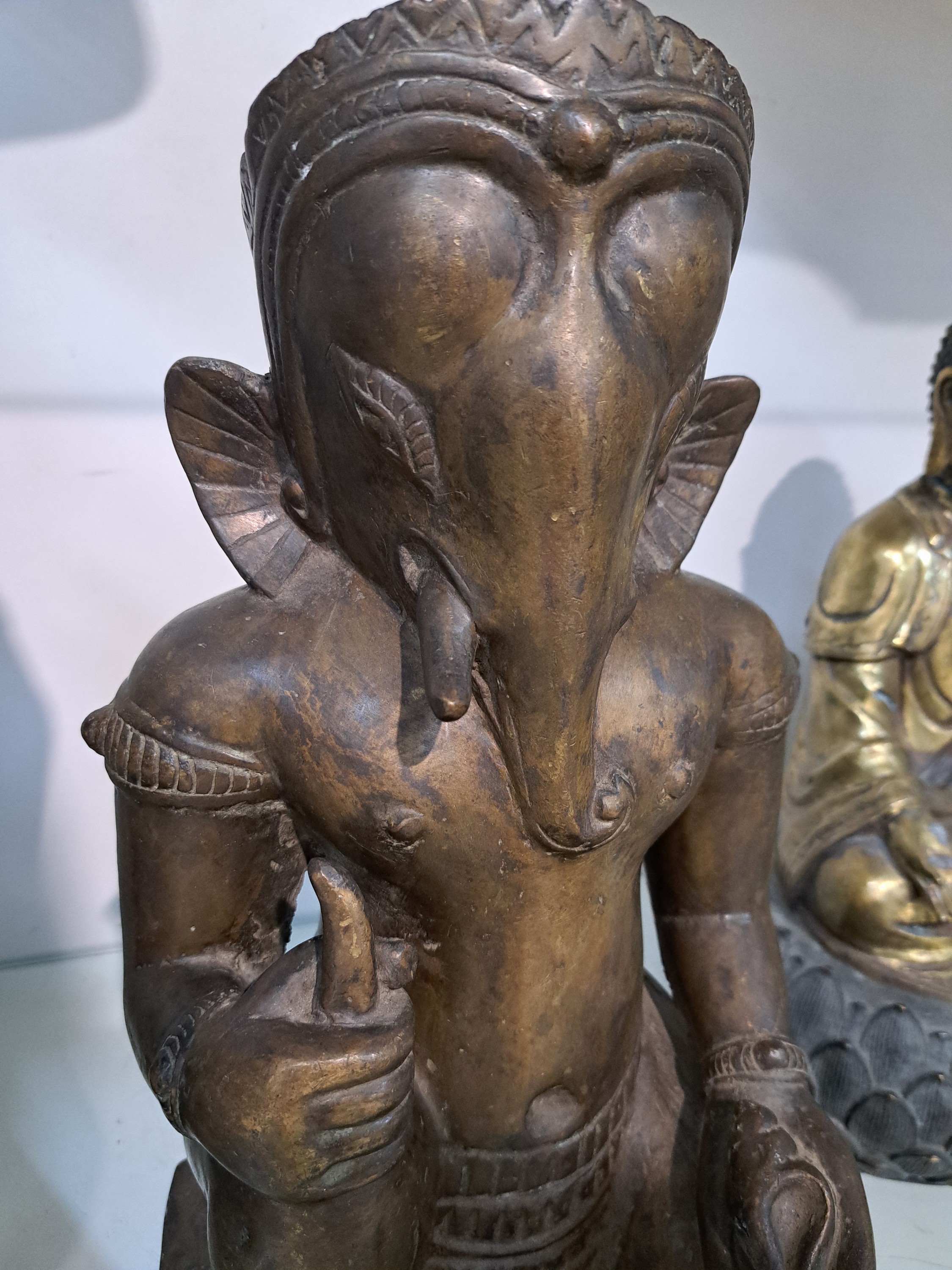 Detail b: Große Bronzefigur, Ganesha, Khmer-Stil, wohl 19. Jh., kniende Darstellung, in einer Hand Shankha (Muschel) in der anderen Hand den abgebrochenen ...