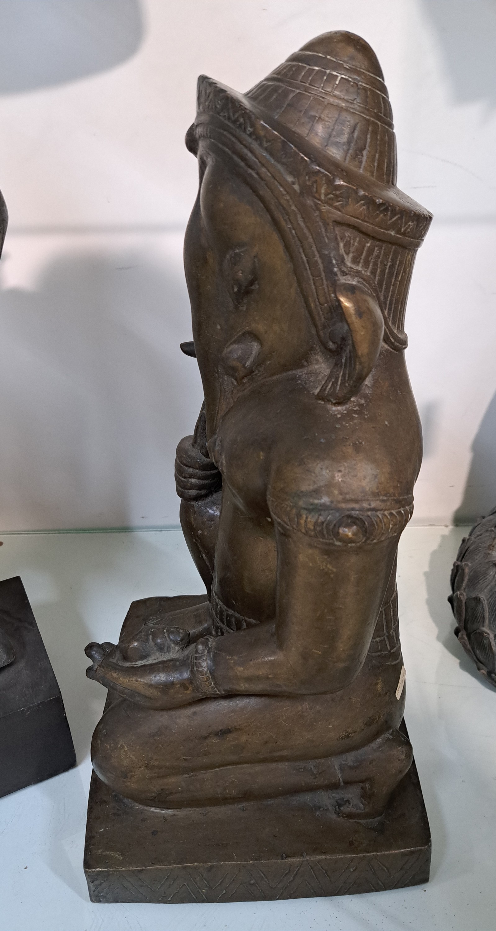 Detail d: Große Bronzefigur, Ganesha, Khmer-Stil, wohl 19. Jh., kniende Darstellung, in einer Hand Shankha (Muschel) in der anderen Hand den abgebrochenen ...